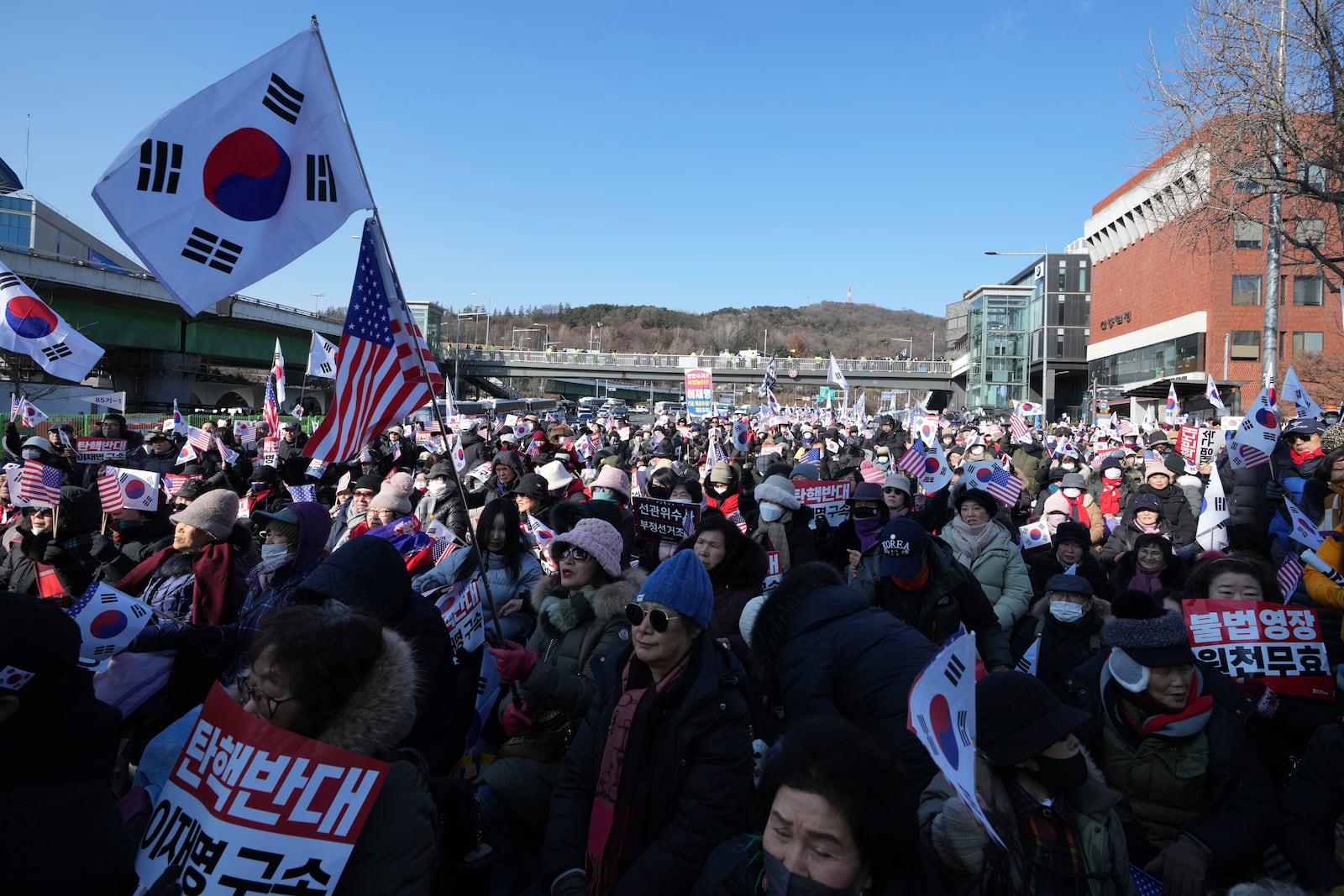 Supporters of impeached South Korean President Yoon Suk Yeol stage a rally to oppose a court having issued a warrant to detain Yoon, near the presidential residence in Seoul, South Korea, Friday, Jan. 3, 2025. The letters read, "Oppose Impeachment." (AP Photo/Lee Jin-man)