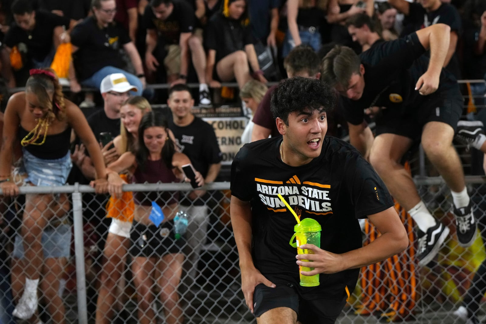 Arizona State fans rush the field after defeating Utah 27-19 during an NCAA college football game, Friday, Oct. 11, 2024, in Tempe, Ariz. (AP Photo/Rick Scuteri)