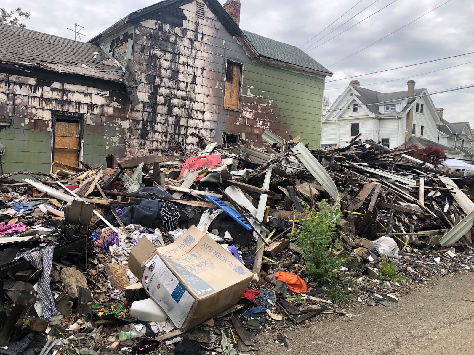 Neighbors say the pile of fire debris at 154 S. Irwin Ave. in Dayton attracts illegal dumping and is an eyesore. CORNELIUS FROLIK / STAFF