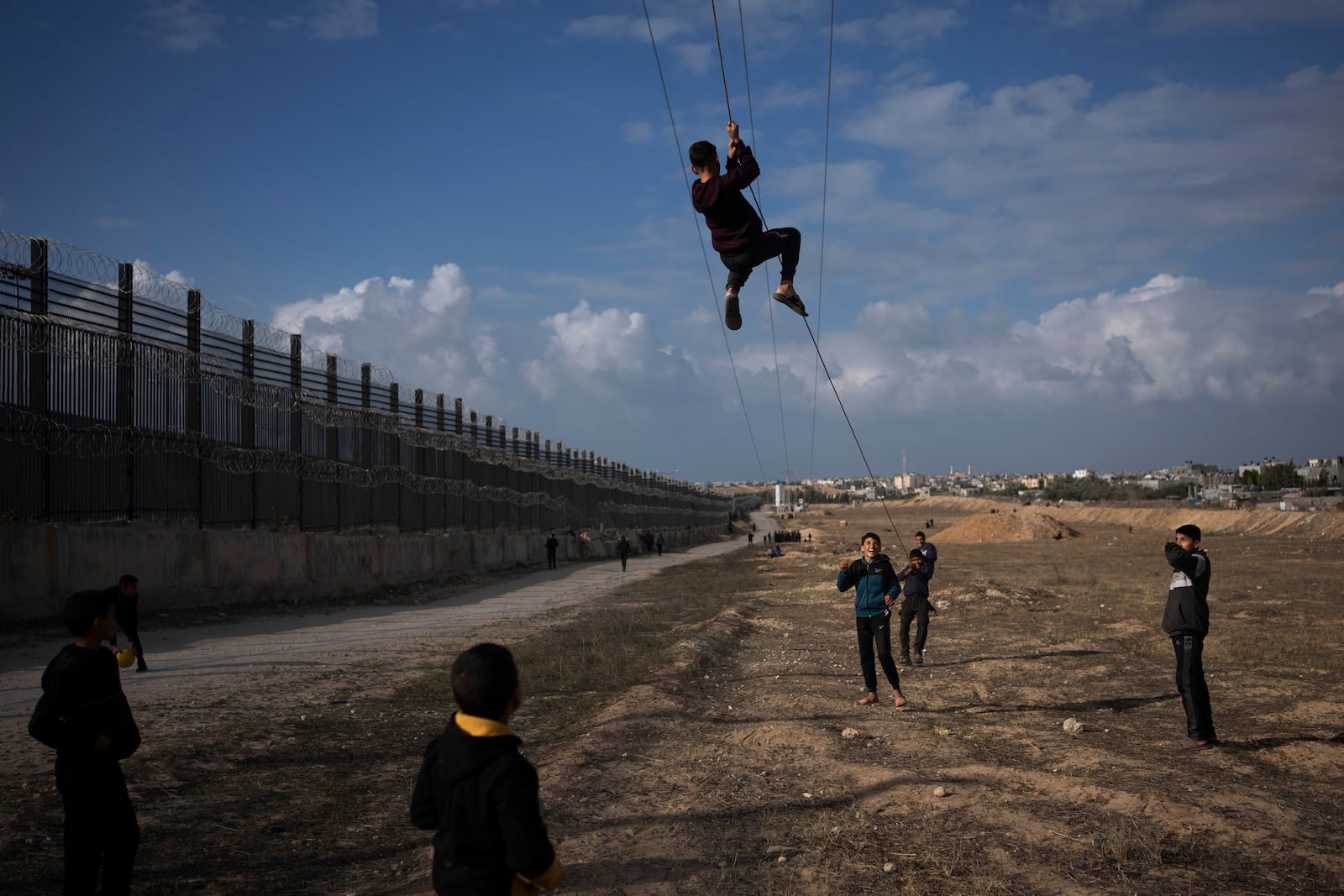 FILE - Palestinians displaced by the Israeli bombardment of the northern Gaza Strip play next to the border with Egypt, in Rafah, along the Philadelphi corridor, southern Gaza, Jan. 14, 2024. (AP Photo/Fatima Shbair, File)