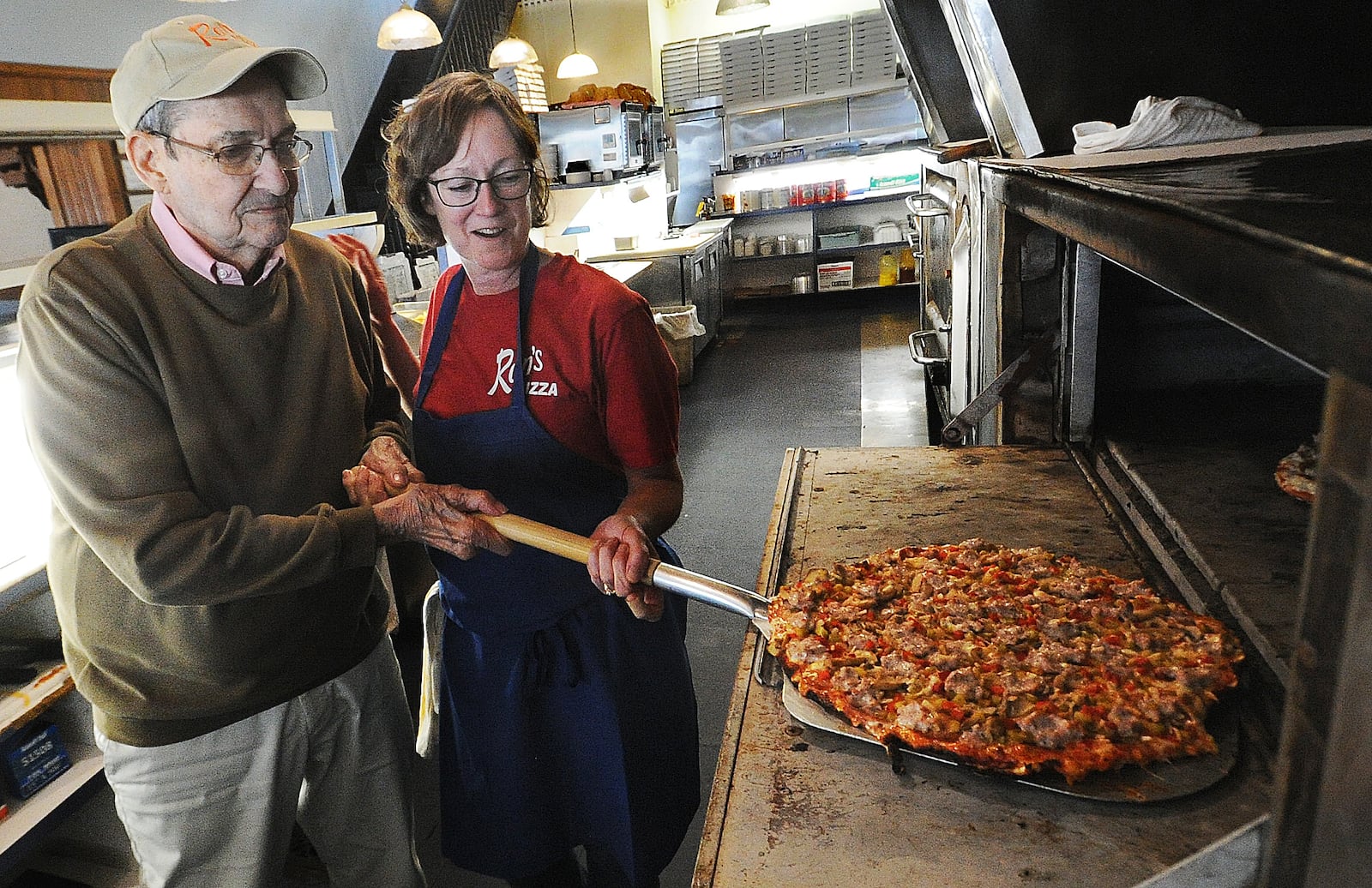 Ron Holp and his daughter, Abbie Romero, remove a pizza from the oven at Ron's Pizza in downtown Miamisburg Thursday, Jan. 5, 2023. The business is in the process of wrapping up remodeling that has taken more than a year. MARSHALL GORBY/STAFF