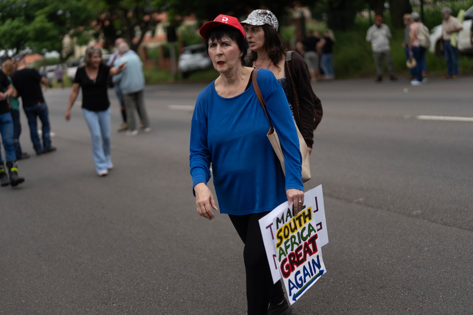 White South Africans demonstrate in support of U.S. President Donald Trump in front of the U.S. embassy in Pretoria, South Africa, Saturday, Feb. 15, 2025. (AP Photo/Jerome Delay)