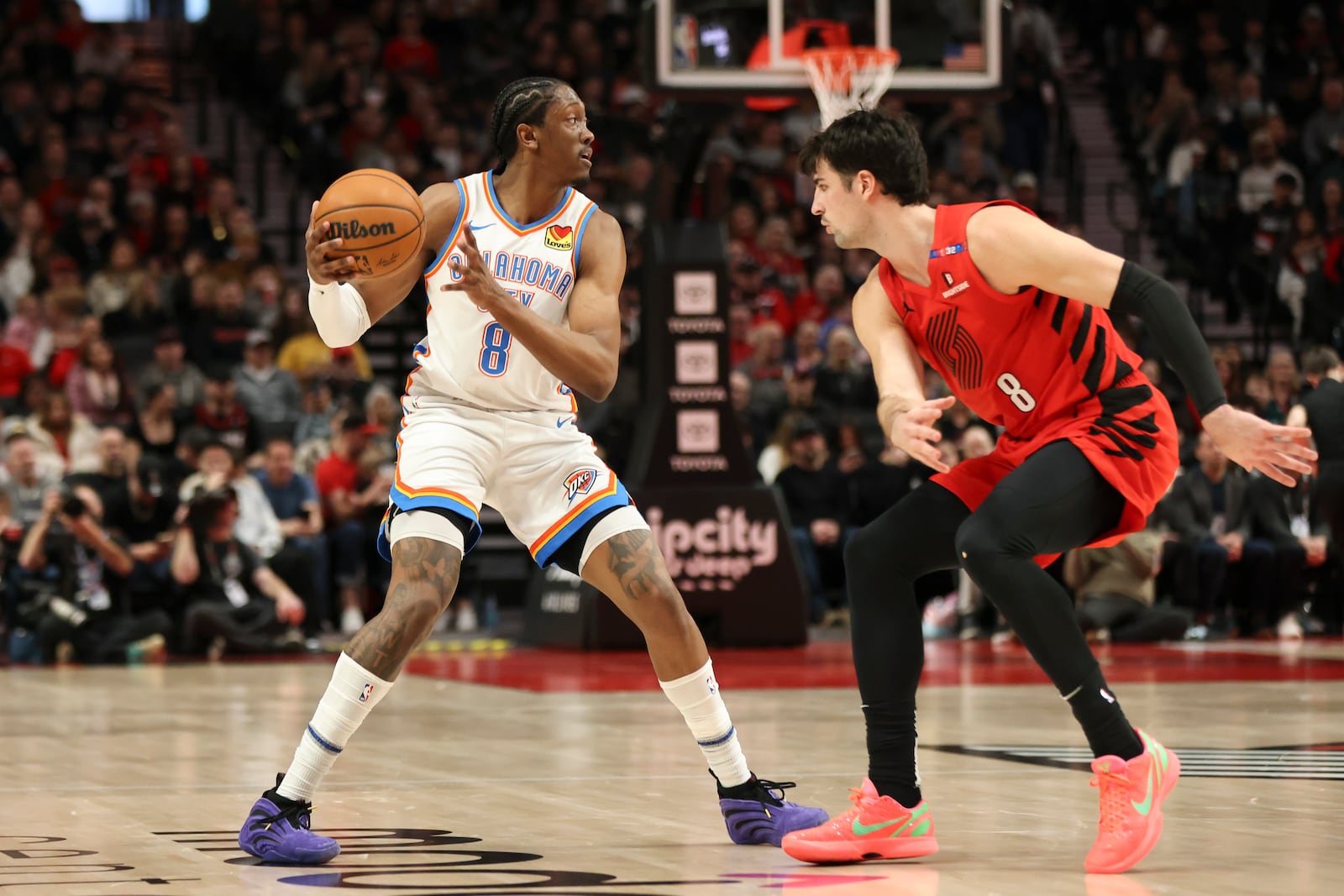 Oklahoma City Thunder forward Jalen Williams, left, looks to pass the ball away from Portland Trail Blazers forward Deni Avdija, right, during the first half of an NBA basketball game Sunday, Jan. 26, 2025, in Portland, Ore. (AP Photo/Amanda Loman)