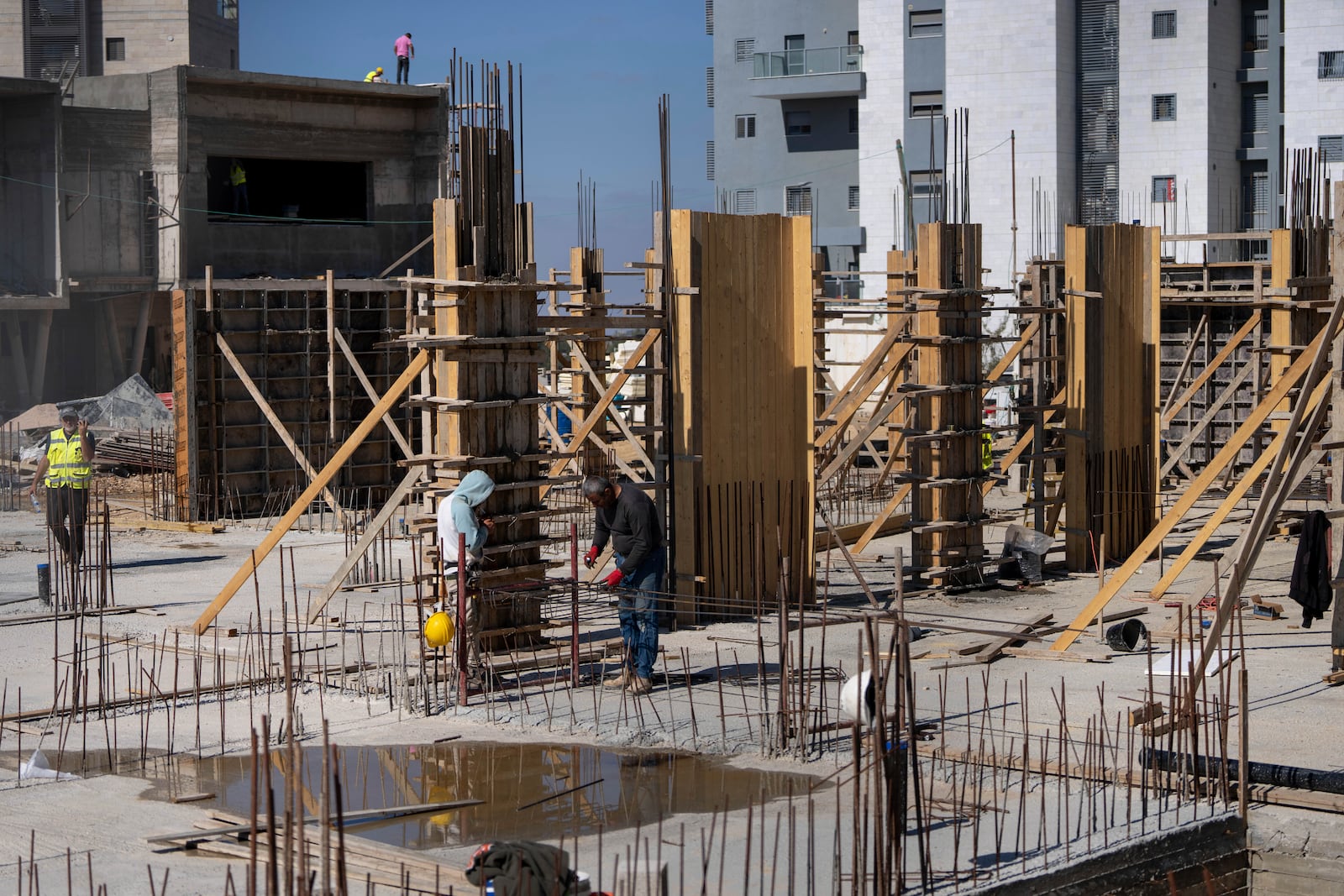 FILE - Palestinian laborers work at the site of a new housing project in the West Bank Jewish Settlement of Beit El, Monday, Nov. 11, 2024. (AP Photo/Ohad Zwigenberg, File)