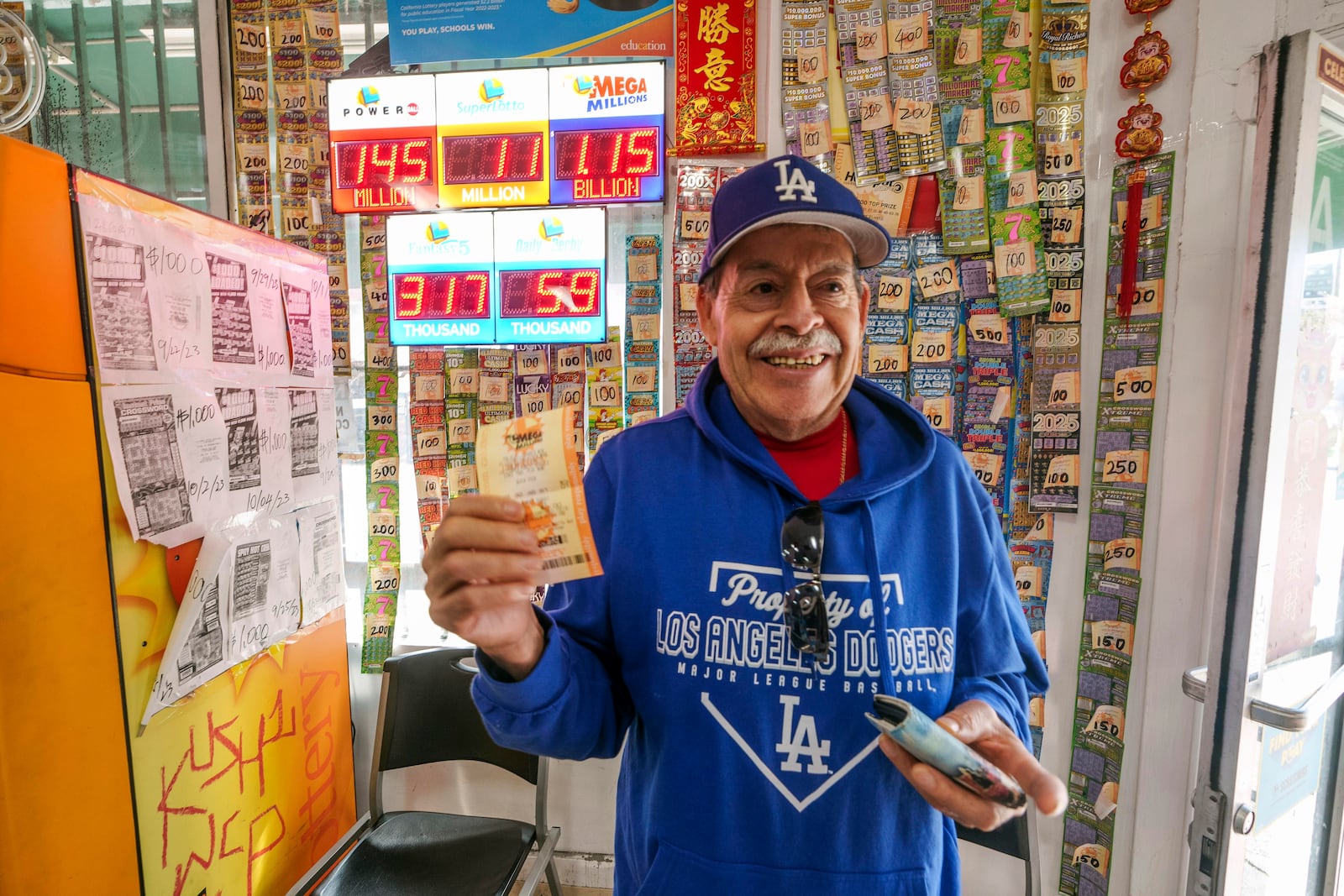 Fidel Lule buys a MegaMillion lottery ticket at Won Won Mini Mart in Chinatown Los Angeles, Thursday, Dec. 26, 2024. (AP Photo/Damian Dovarganes)