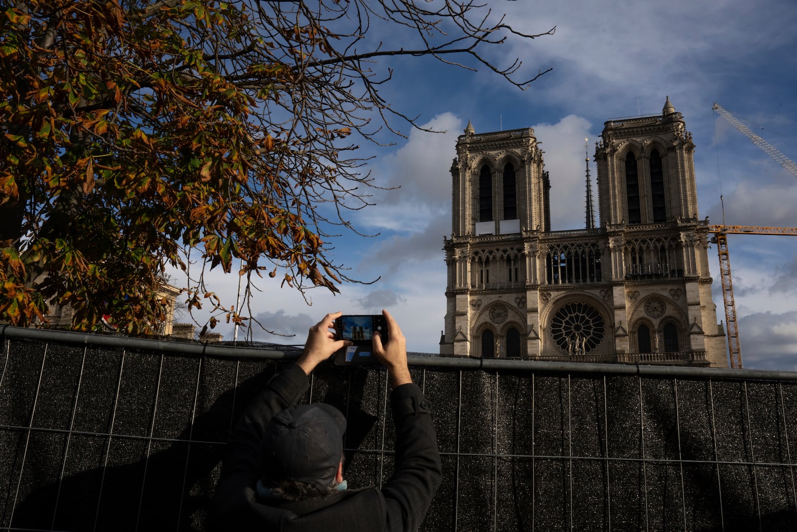 A visitor takes photographs of Notre-Dame cathedral in Paris, Wednesday, Nov. 20, 2024. (AP Photo/Louise Delmotte)