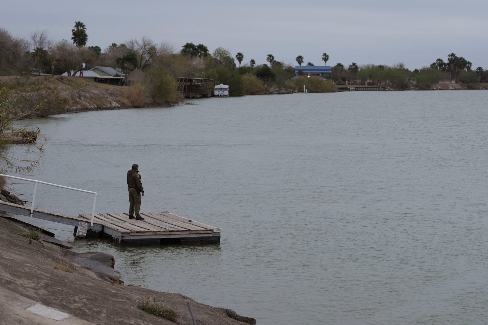 A border patrol agent waits for a patrol boat at the Rio Grande, Thursday, Feb. 13, 2025, in McAllen, Texas. (AP Photo/Eric Gay)