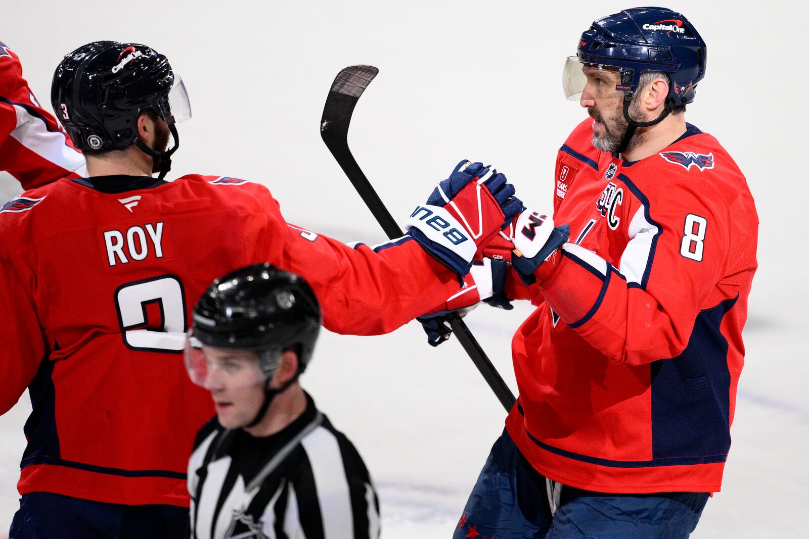 Washington Capitals left wing Alex Ovechkin (8) celebrates his empty net goal with defenseman Matt Roy (3) during the third period of an NHL hockey game against the Florida Panthers, Tuesday, Feb. 4, 2025, in Washington. (AP Photo/Nick Wass)