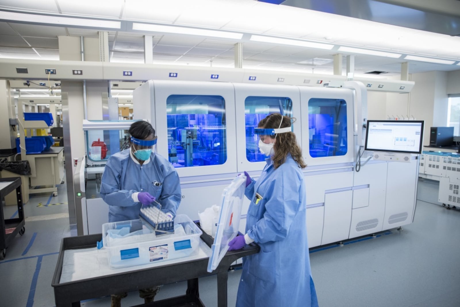 Staff Sgt. Alexis Shodeke (left) and Renee Mayhon, both medical laboratory technicians in the United States Air Force School of Aerospace Medicine’s Epidemiology Laboratory, prepare to load new samples onto the Roche 8800 for COVID polymerise chain reaction testing.  (U.S. Air Force photo by Richard Eldridge)