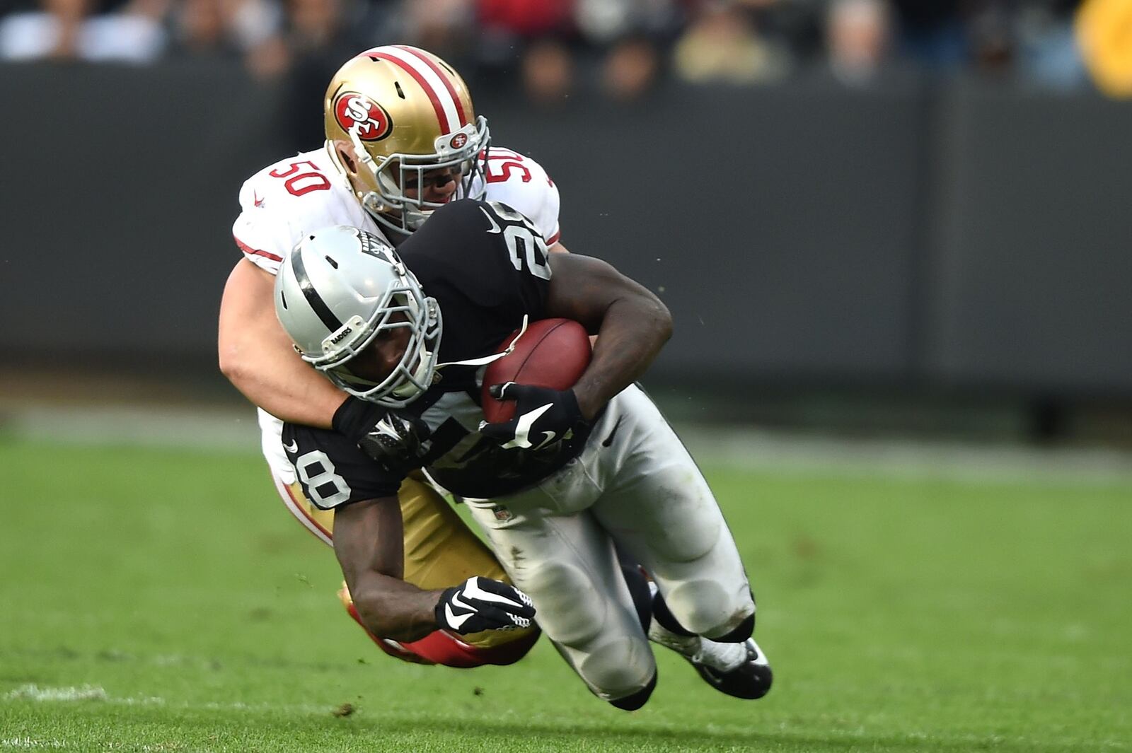 OAKLAND, CA - DECEMBER 07: Latavius Murray #28 of the Oakland Raiders is tackled by Chris Borland #50 of the San Francisco 49ers in the second quarter at O.co Coliseum on December 7, 2014 in Oakland, California. (Photo by Thearon W. Henderson/Getty Images)