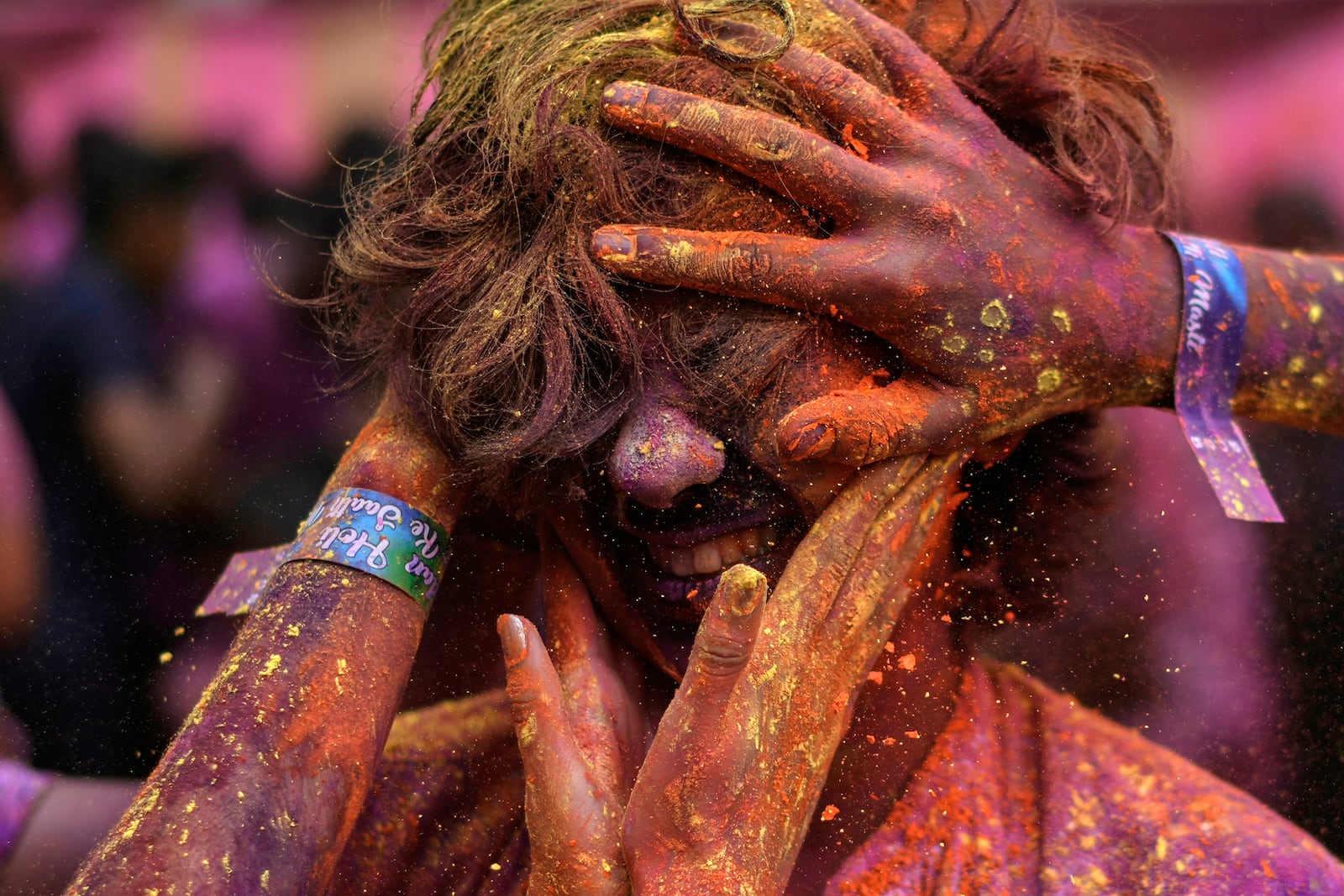 A woman has her face smeared with coloured powder as they celebrate Holi, the festival of colours, in Chennai, India, Friday, March 14, 2025. (AP Photo/Mahesh Kumar A.)