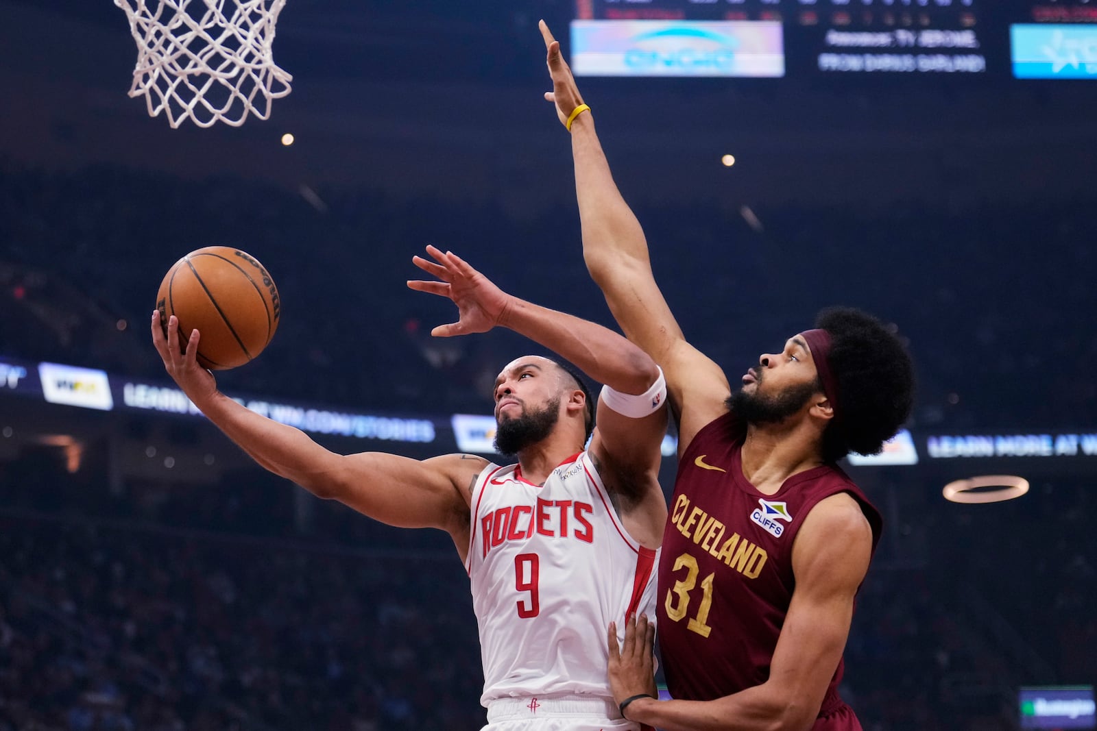 Houston Rockets forward Dillon Brooks (9) goes to the basket defended by Cleveland Cavaliers center Jarrett Allen (31) in the first half of an NBA basketball game, Saturday, Jan. 25, 2025, in Cleveland. (AP Photo/Sue Ogrocki)