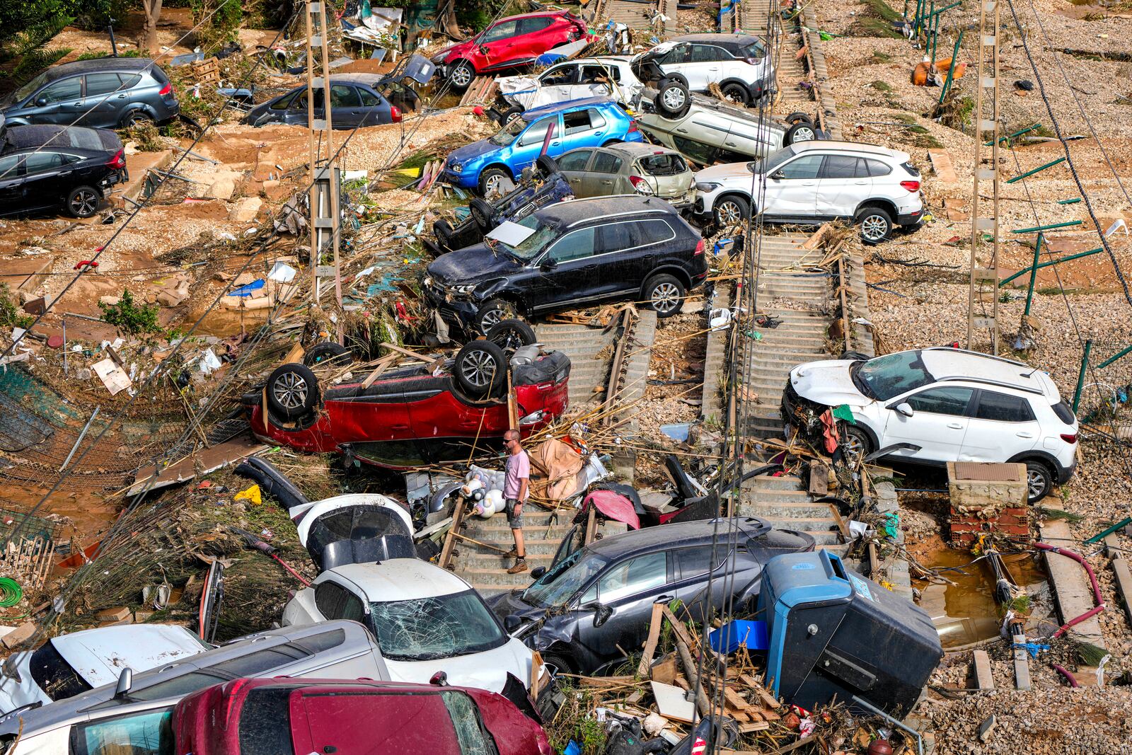 A man stands among flooded cars piled up in Valencia, Spain, Thursday, Oct. 31, 2024. (AP Photo/Manu Fernandez)