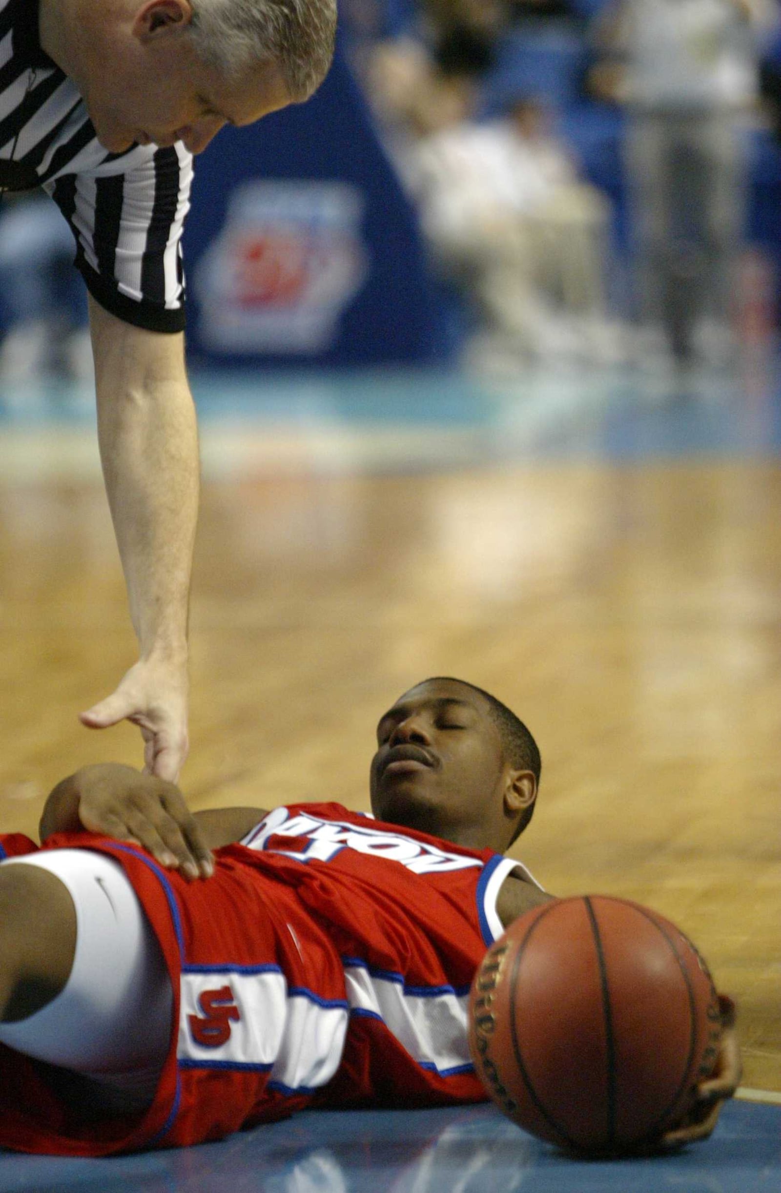 Dayton's Warren Williams is helped up by a referee in the second overtime during a NCAA tournament game against DePaul in 2004.