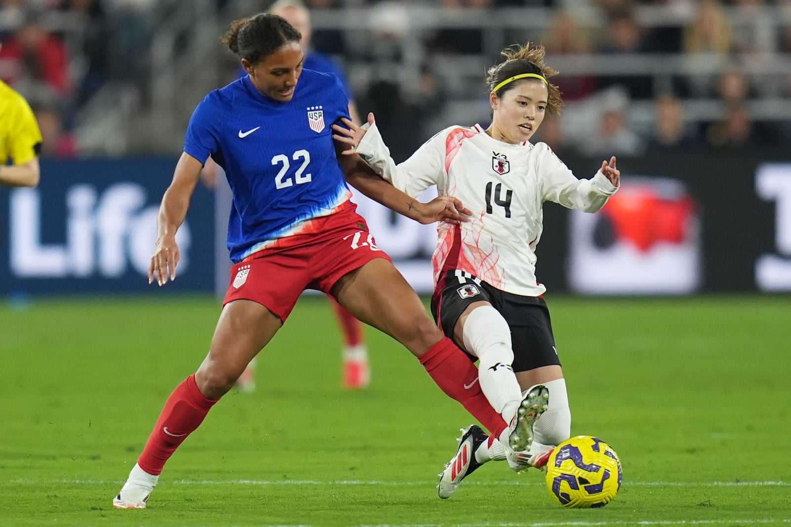 Japan midfielder Yui Hasegawa (14) battles United States forward Yazmeen Ryan for the ball during the first half of a SheBelieves Cup women's soccer tournament match Wednesday, Feb. 26, 2025, in San Diego. (AP Photo/Gregory Bull)