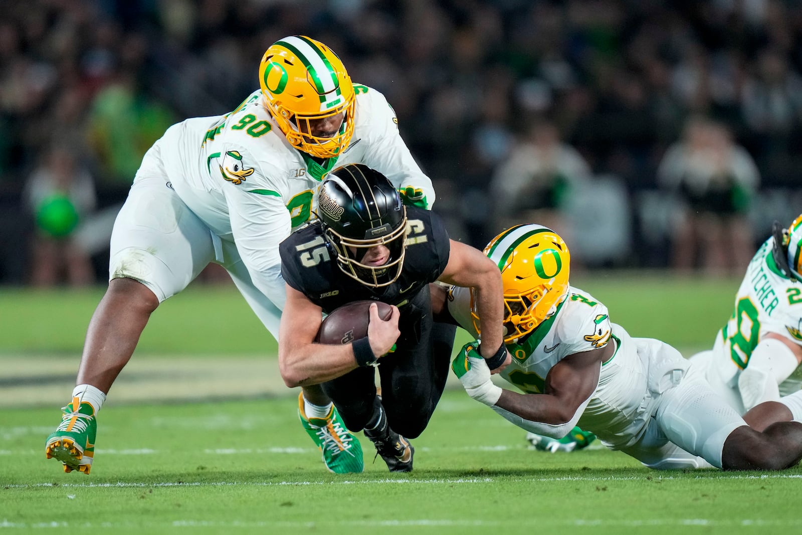 Purdue quarterback Ryan Browne (15) is tackled by Oregon linebacker Jeffrey Bassa (2) during the first half of an NCAA college football game in West Lafayette, Ind., Friday, Oct. 18, 2024. (AP Photo/AJ Mast)