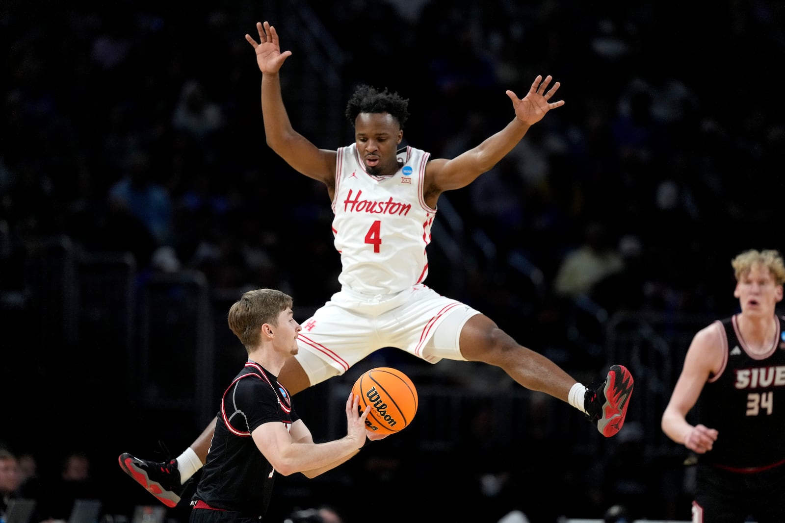 SIU Edwardsville guard Declan Dillon, looks to pass around Houston guard L.J. Cryer (4) during the first half of a first round game of the NCAA college basketball tournament, Thursday, March 20, 2025, in Wichita, Kan. (AP Photo/Charlie Riedel)