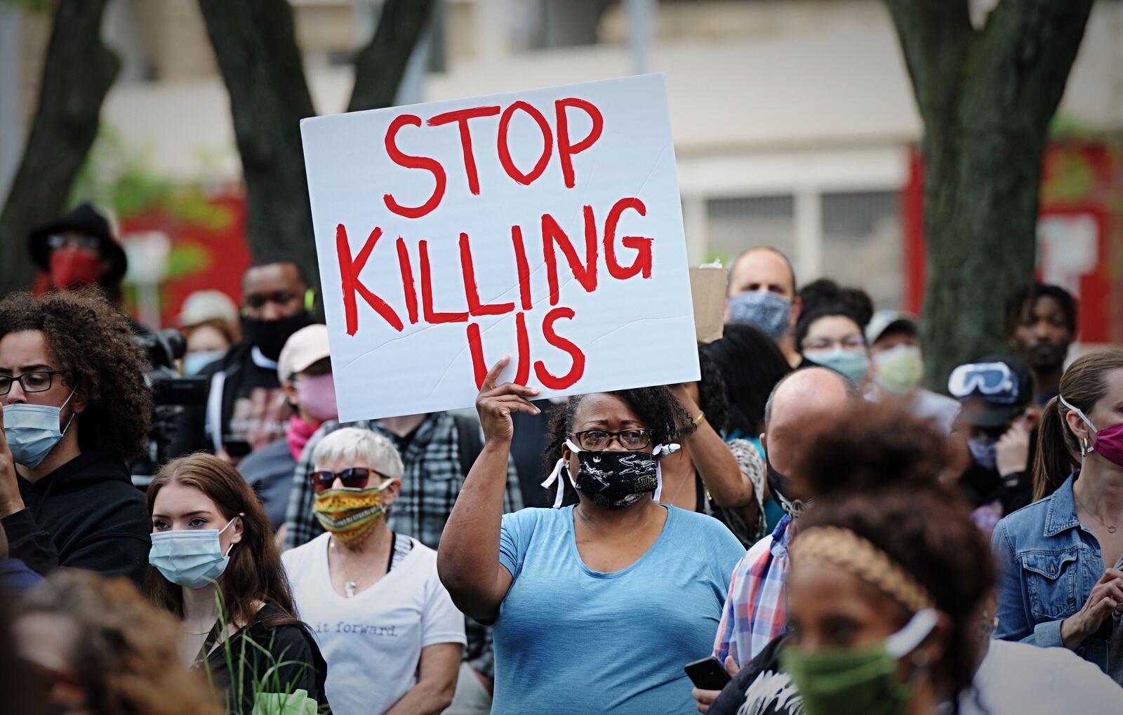 Protesters hold signs and march Saturday, May 30, 2020, in Dayton, following the death of George Floyd, an unarmed black man, by police in Minneapolis. MARSHALL GORBY / STAFF