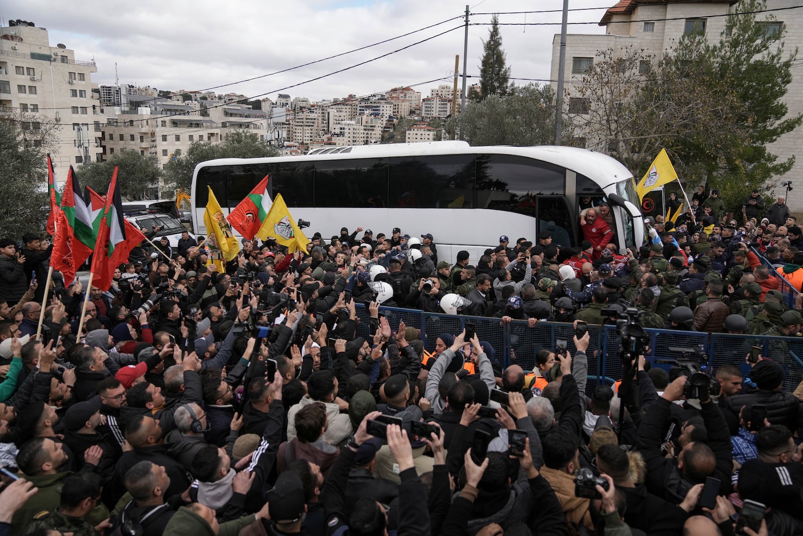 Palestinian prisoners are greeted as they exit a Red Cross bus after being released from Israeli prison following a ceasefire agreement between Israel and Hamas, in the West Bank city of Ramallah, Saturday Feb. 8, 2025. (AP Photo/Mahmoud Illean)