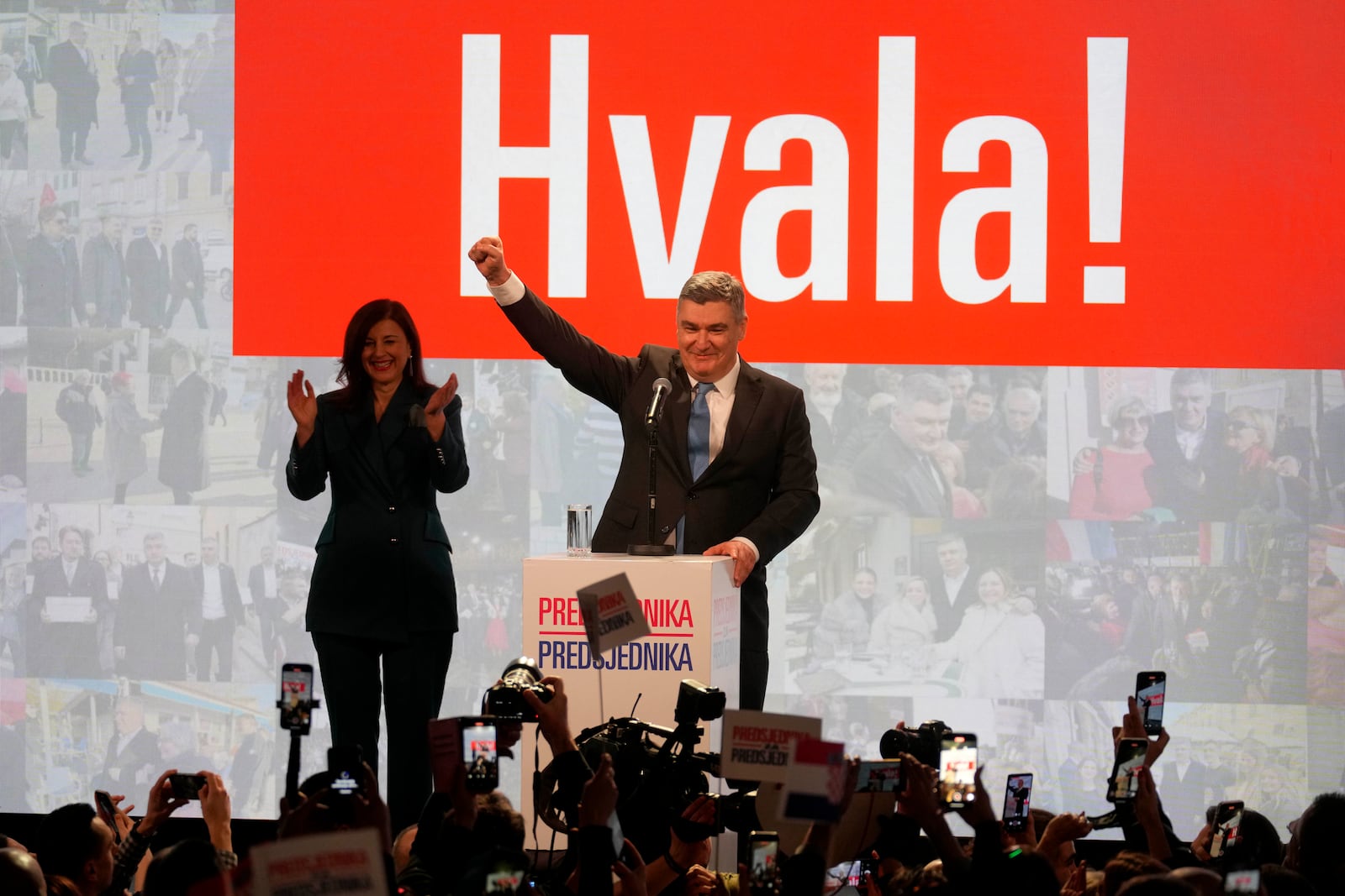 President incumbent Zoran Milanovic with his wife Sanja Music Milanovic greets supporters as the preliminary results grant him victory in a runoff vote for the Croatian presidential election in Zagreb, Croatia, Sunday, Jan. 12, 2025. The sign reads "Thank You". (AP Photo/Darko Bandic)