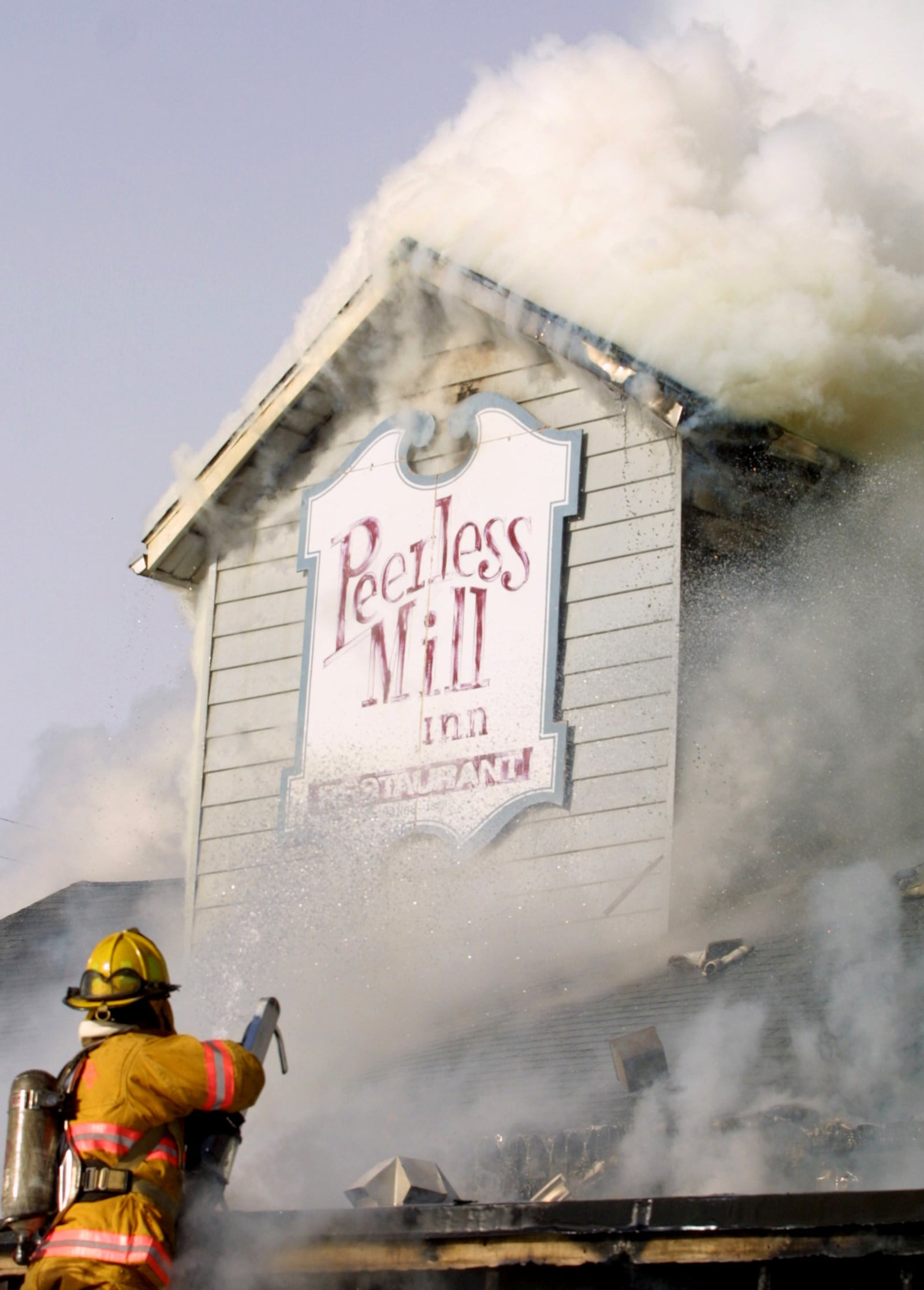 A Miamisburg firefighter puts out a 2003 fire  at the Peerless Mill Inn, a restaurant in Miamisburg. STAFF FILE PHOTO