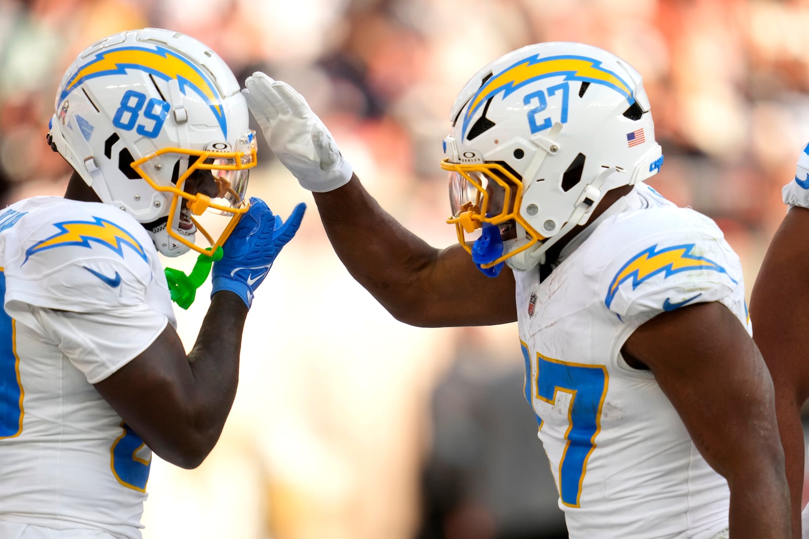 Los Angeles Chargers running back J.K. Dobbins (27) celebrates with Jalen Reagor (89) after Dobbins scored a touchdown in the second half of an NFL football game against the Cleveland Browns Sunday, Nov. 3, 2024, in Cleveland. (AP Photo/Sue Ogrocki)