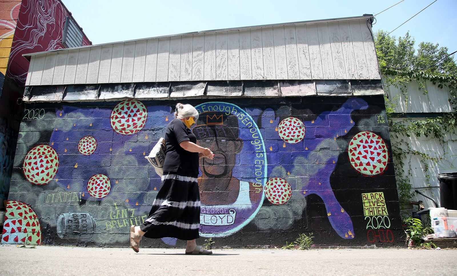 Two new murals in Yellow Springs pay tribute to George Floyd and the global protest movement held in response to his death. Artists Pierre Nagley and Lindsay Burke have created the murals in Kieth’s Alley, an area stretching behind the businesses along Xenia Ave. where artists have painted murals since the late 1980s. LISA POWELL / STAFF