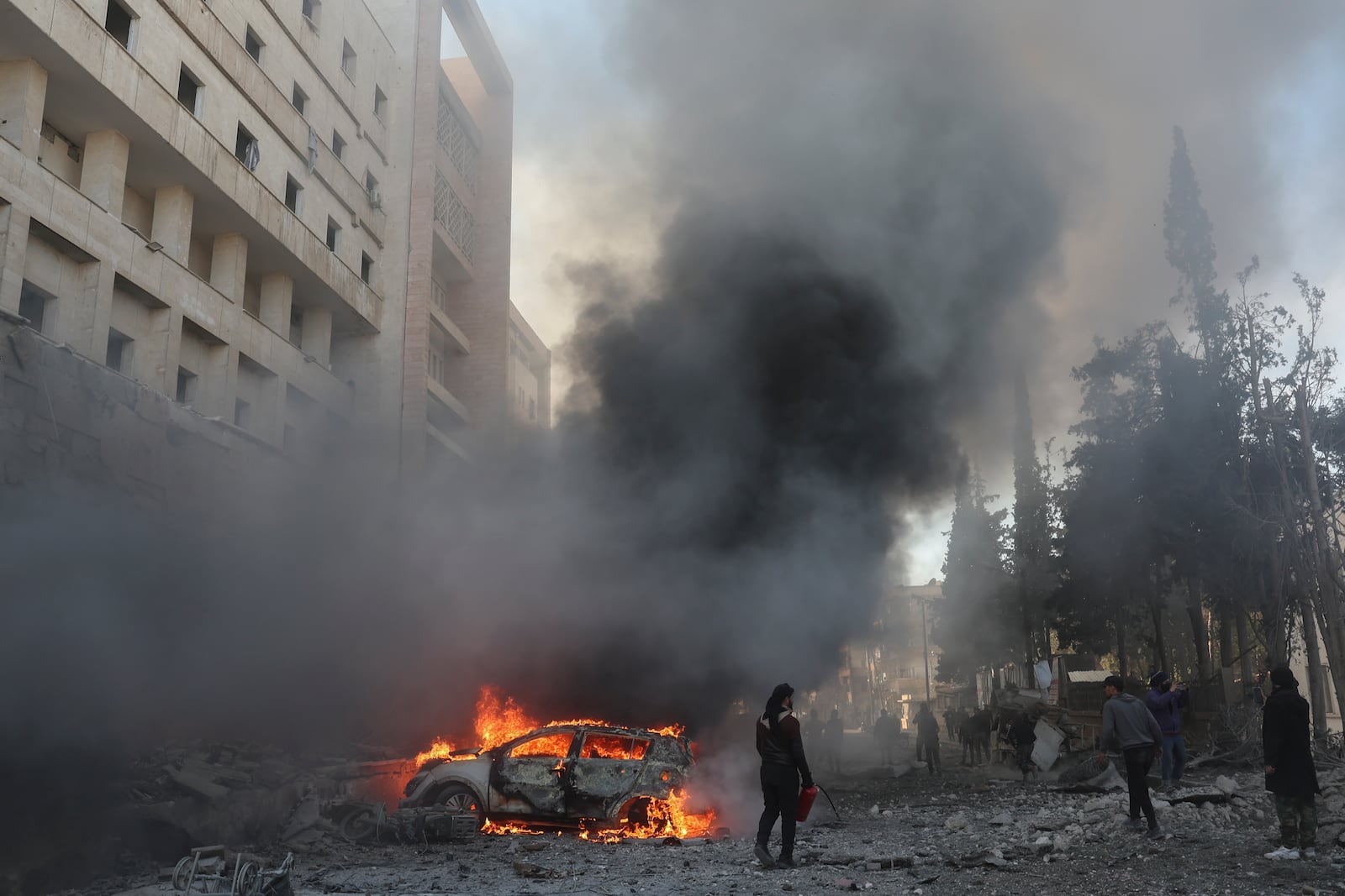 A car burns after an airstrike next to a hospital in Idlib, Syria, Monday Dec.2, 2024.(AP Photo/Ghaith Alsayed)