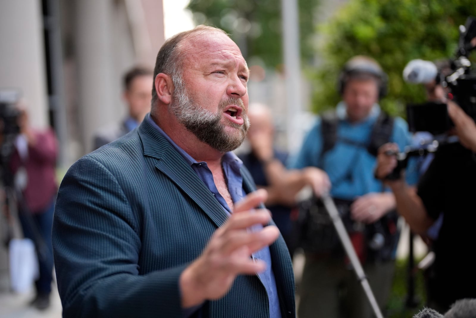 FILE - Right-wing conspiracy theorist Alex Jones speaks to the media after arriving at the federal courthouse for a hearing in front of a bankruptcy judge, Friday, June 14, 2024, in Houston. (AP Photo/David J. Phillip, File)