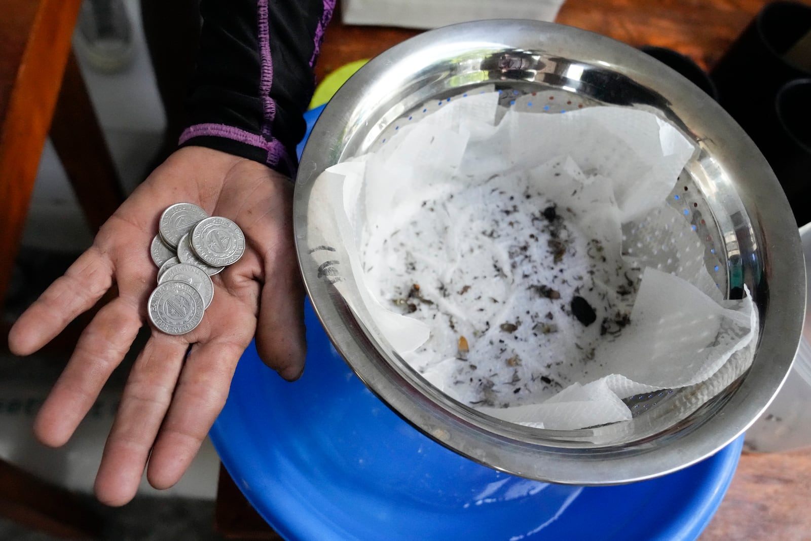 Michael Labag shows the 9 pesos reward he got from the 45 mosquito larvas he captured in Mandaluyong city, Philippines as the village started offering bounty for captured mosquitos, dead or alive, as part of an anti-dengue campaign on Wednesday, Feb. 19, 2025. (AP Photo/Aaron Favila)