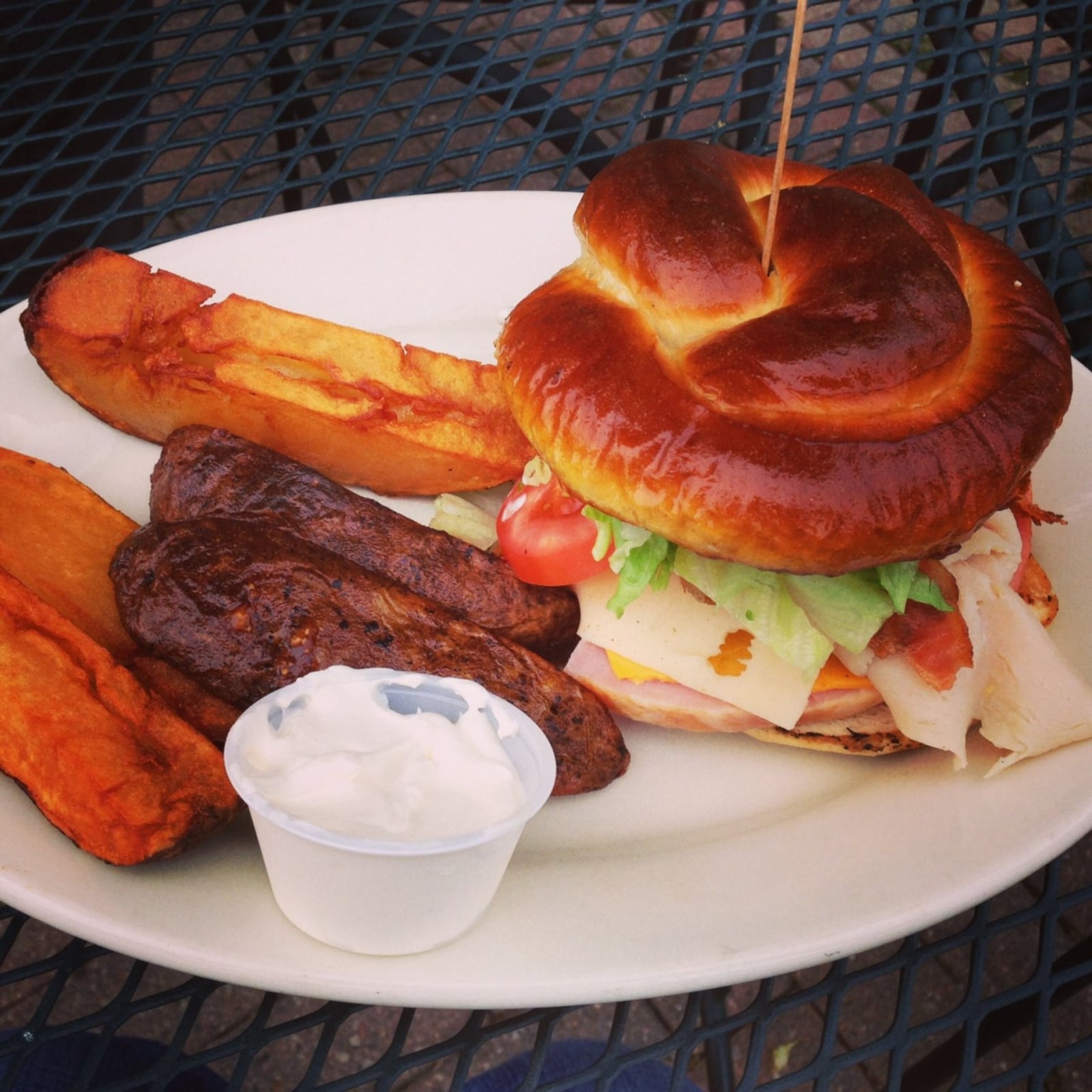 Behold, The Sexy Club: Sliced ham, turkey and bacon with lettuce, tomato, American and Swiss cheese on a pretzel bun, with enormous broasted wedge fries and sour cream on the side. At Nick’s Restaurant in Xenia. (Staff photo by Connie Post)