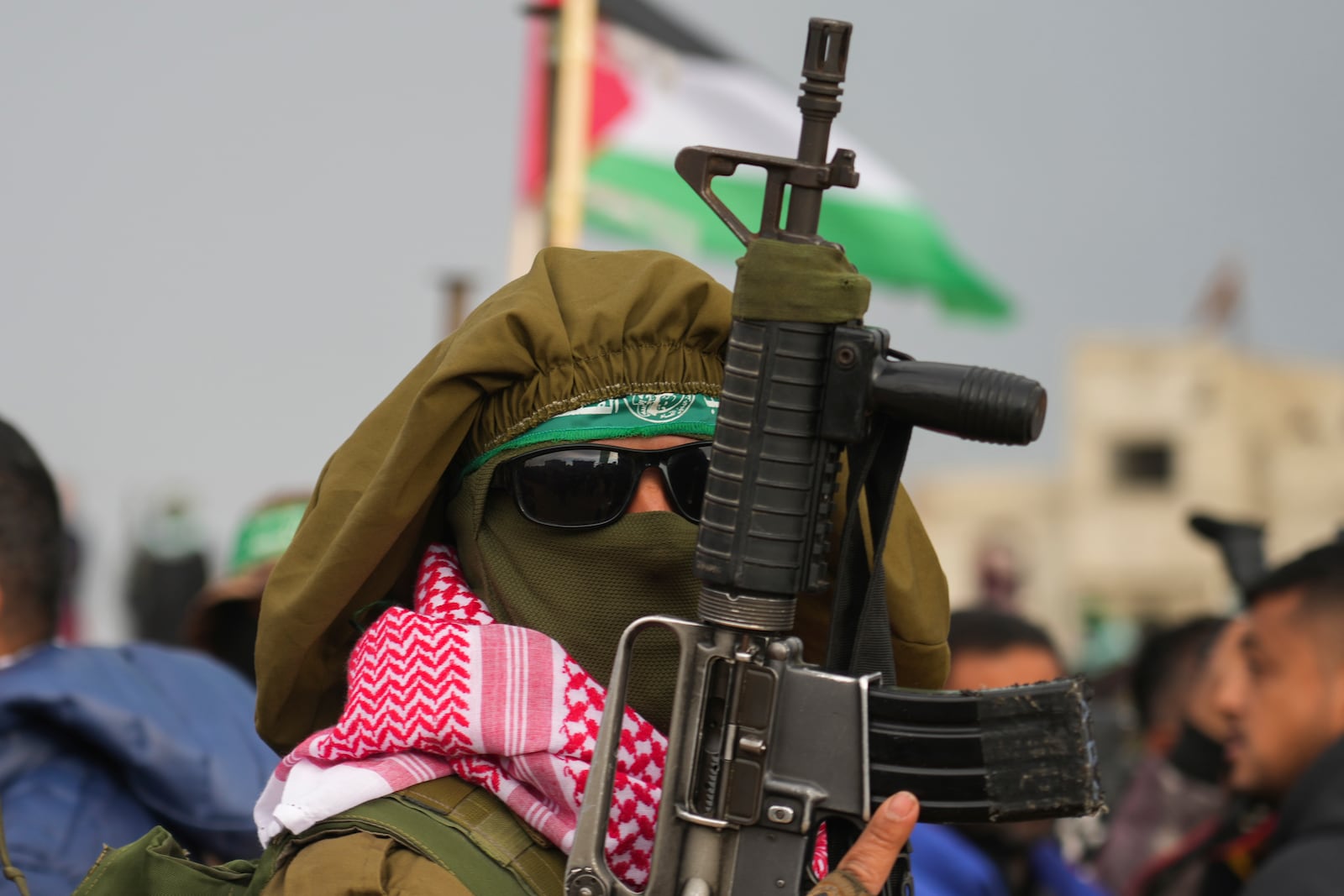 A Hamas fighter takes up a position ahead of handing over the bodies of four Israeli hostages, including a mother and her two children, who had long been feared dead, to the Red Cross in Khan Younis, southern Gaza Strip, Thursday, Feb. 20, 2025. (AP Photo/Abdel Kareem Hana)