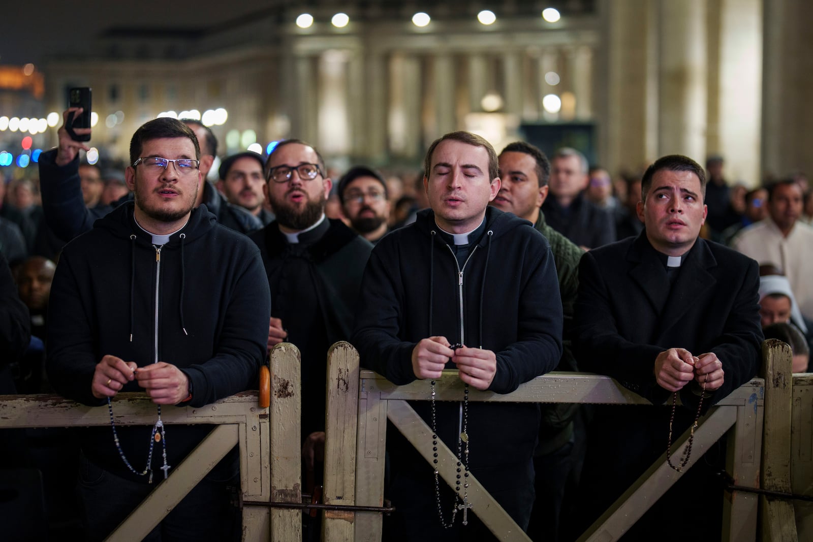 Catholic priests pray the rosary in St. Peter's Square at The Vatican for the recovery of Pope Francis, Monday, Feb. 24, 2025. (AP Photo/Bernat Armangue)