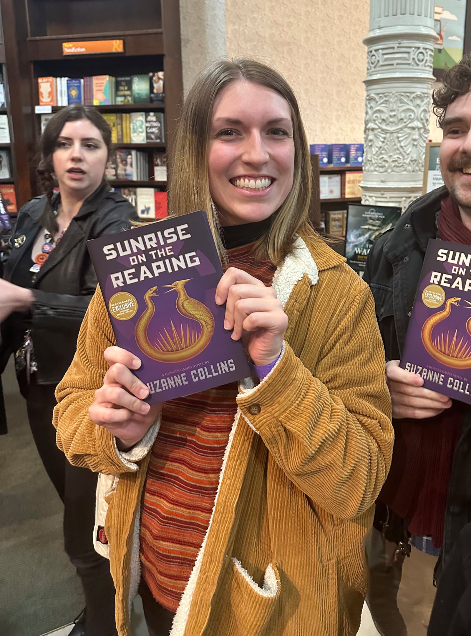 Savannah Miller holds her copy of "Sunrise on the Reaping" by Suzanne Collins at a midnight launch party at Barnes & Noble bookstore in New York on Tuesday, March 18, 2025. (AP Photo/Hillel Italie)