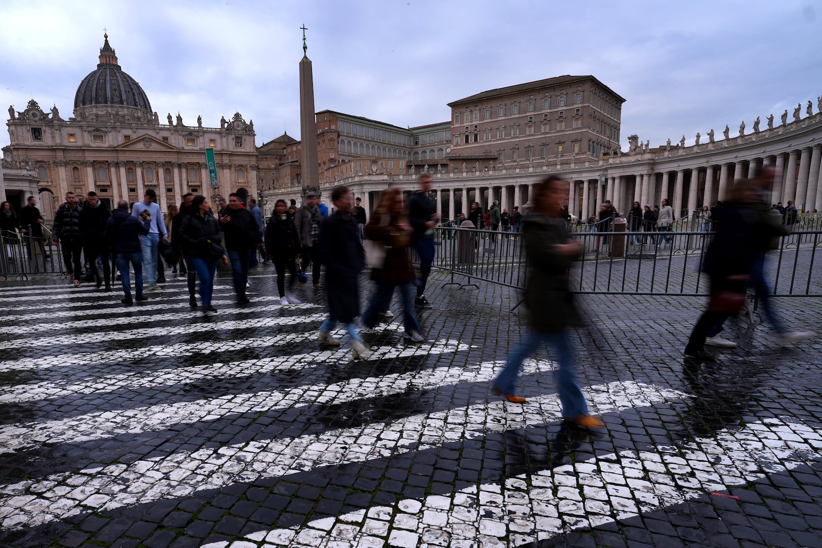 People walk outside St. Peter's Square at The Vatican, Monday, Feb. 24, 2025. (AP Photo/Kirsty Wigglesworth)