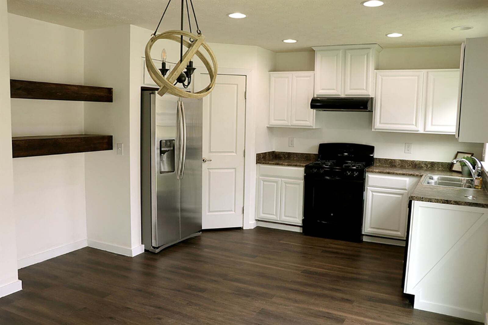 The kitchen has been updated with painted-white cabinetry that fills two walls and complementing countertops. A double sink is below a window and the kitchen comes equipped with a gas range, side-by-side refrigerator and a dishwasher. CONTRIBUTED PHOTO BY KATHY TYLER