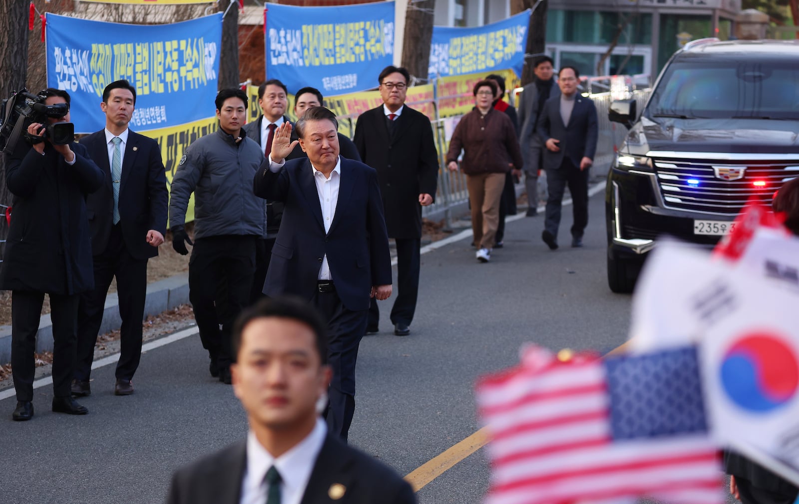 Impeached South Korean President Yoon Suk Yeol waves to his supporters after he came out of a detention center in Uiwang, South Korea, Saturday, March 8, 2025. (Kim Do-hun/Yonhap via AP)