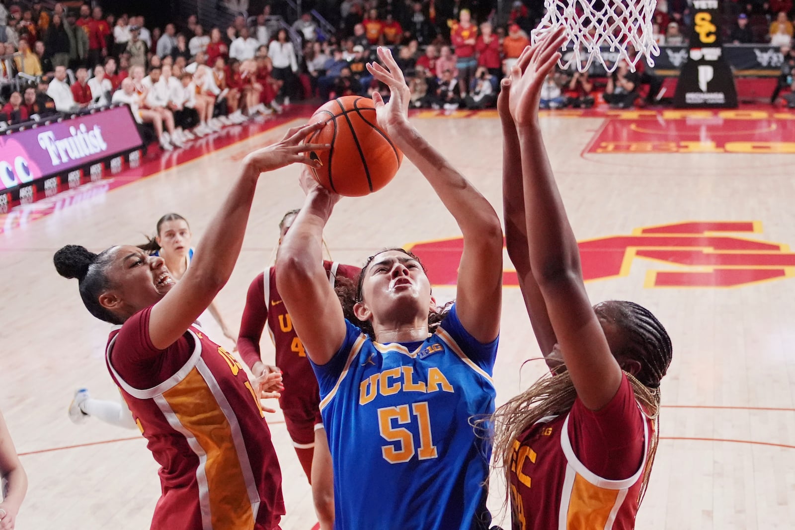 FILE - Southern California guard JuJu Watkins, left, blocks the shot of UCLA center Lauren Betts, center, as center Clarice Akunwafo helps defend during the second half of an NCAA college basketball game, Thursday, Feb. 13, 2025, in Los Angeles. (AP Photo/Mark J. Terrill, File)