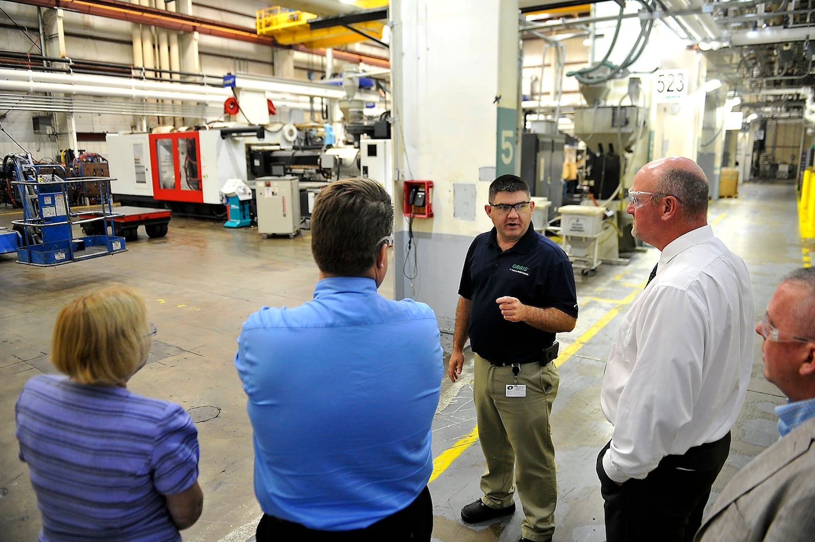 Dan Szklany, plant manager at Orbis in Urbana, leads a tour of the plant for a group from Ohio-Hi Point and Triad. Manufacturing has been a strength in Champaign County’s economy in recent years, according to local experts. Bill Lackey/Staff