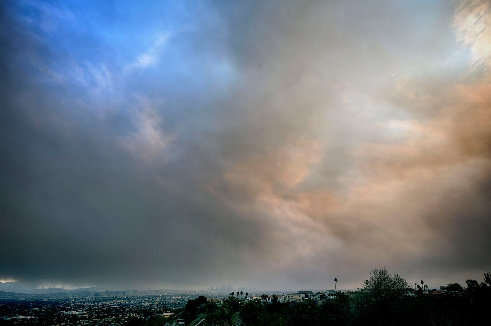 Thick heavy black smoke from wildfires moves in over downtown Los Angeles on Wednesday, Jan. 8, 2025. (AP Photo/Richard Vogel)