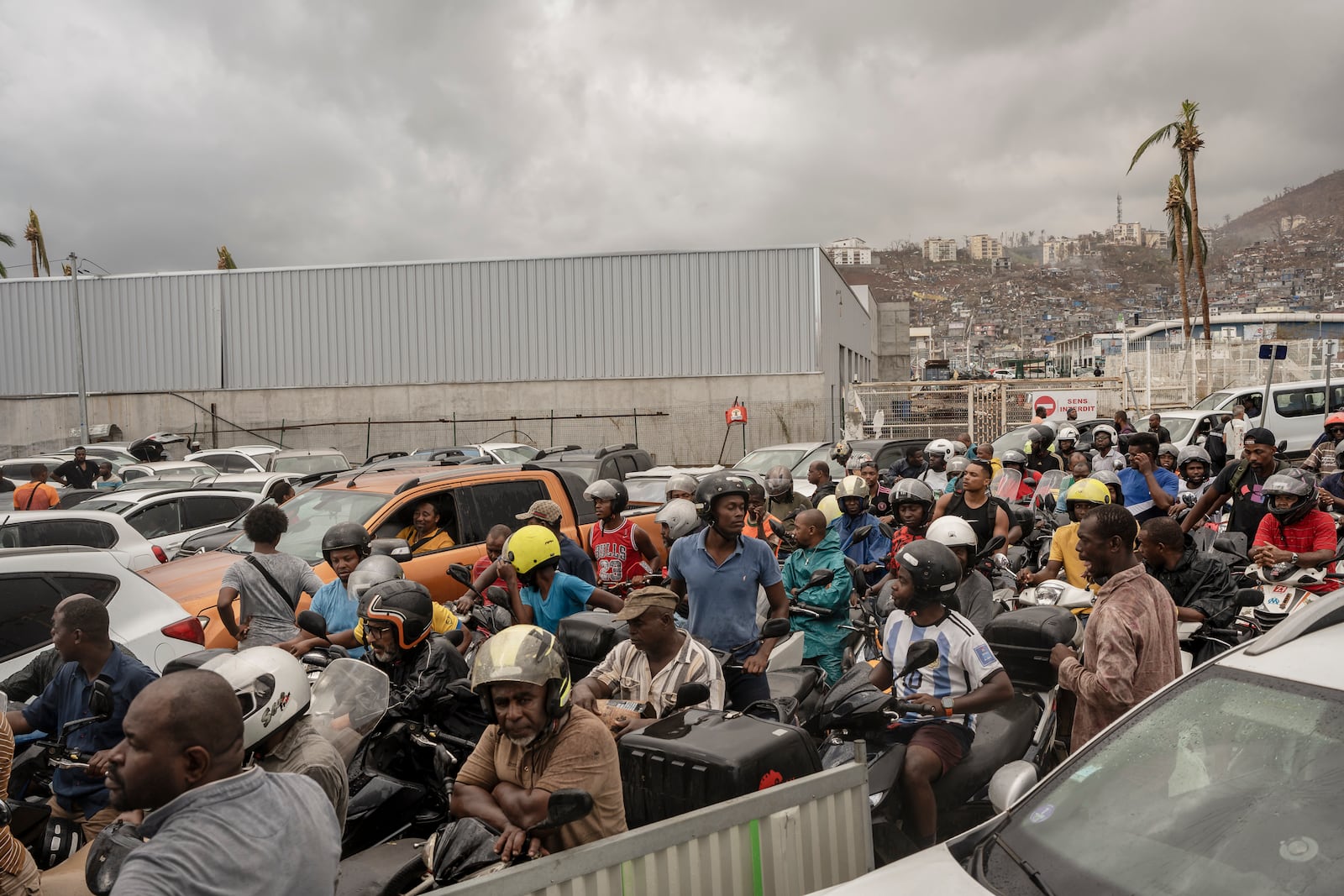 People queue for gas in Mamoudzou, in the French Indian Ocean island of Mayotte, Thursday, Dec. 19, 2024, after Cyclone Chido. (AP Photo/Adrienne Surprenant)