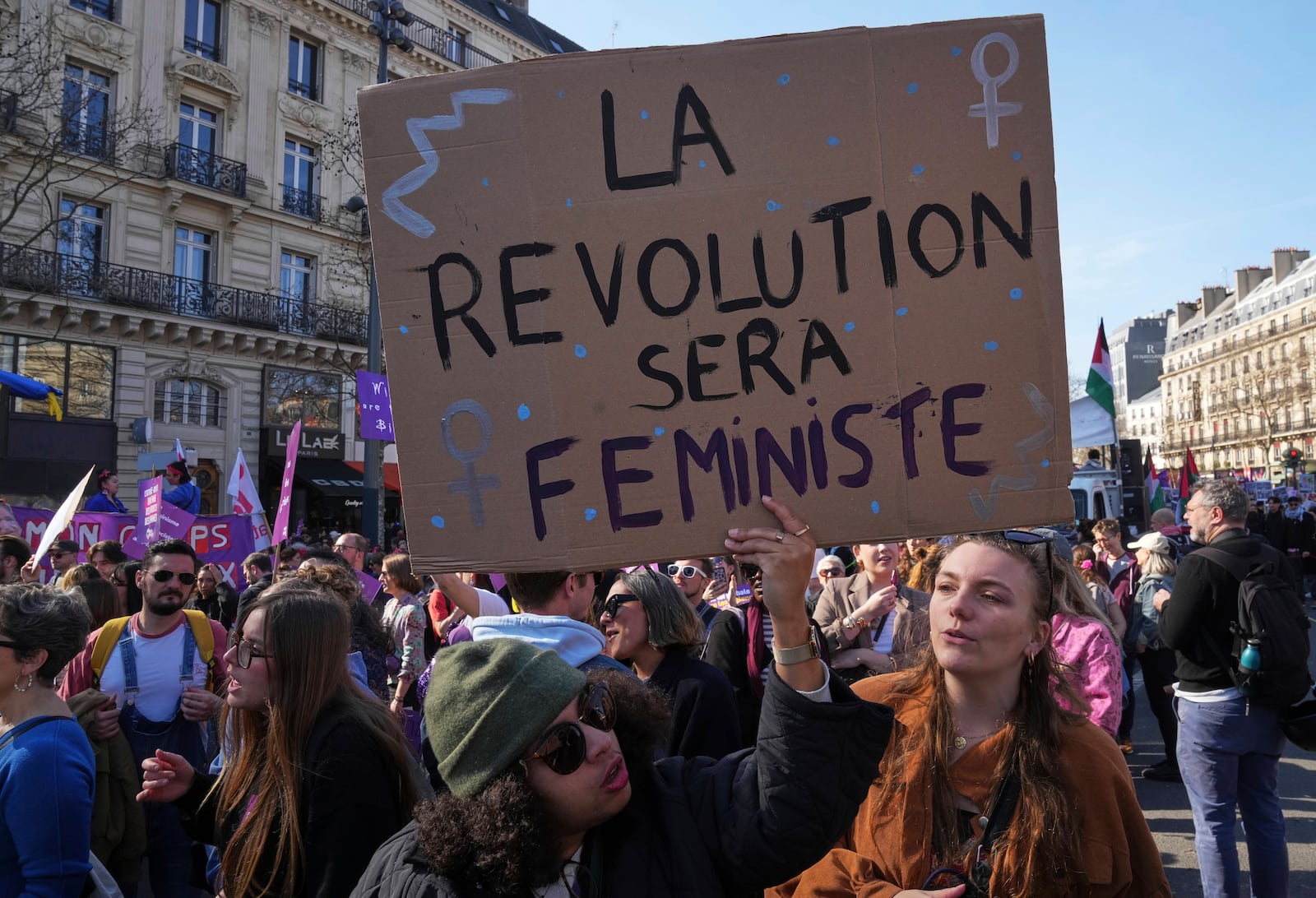 Women take part in a march to mark International Women's Day in Paris, Saturday March 8,, 2025. Placard reads "the revolution will be feminist". (AP Photo/Michel Euler)