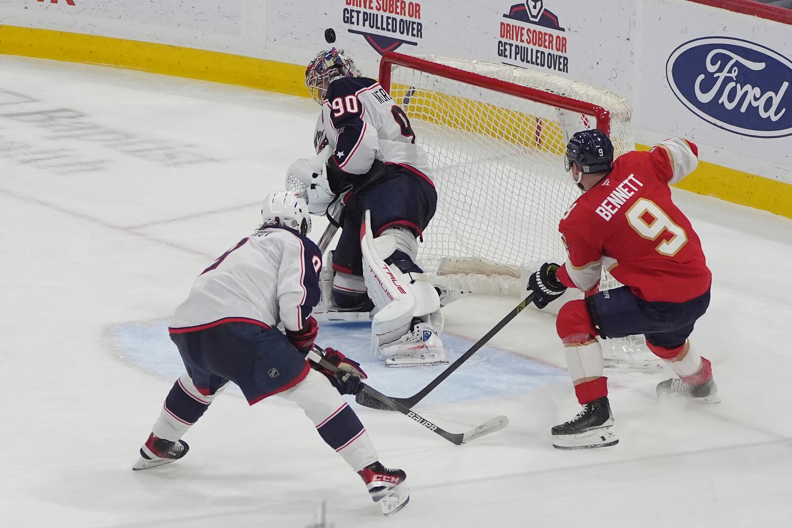 Columbus Blue Jackets goaltender Elvis Merzlikins (90) blocks a shot by Florida Panthers center Sam Bennett (9) during the second period of an NHL hockey game, Thursday, March 6, 2025, in Sunrise, Fla. (AP Photo/Marta Lavandier)