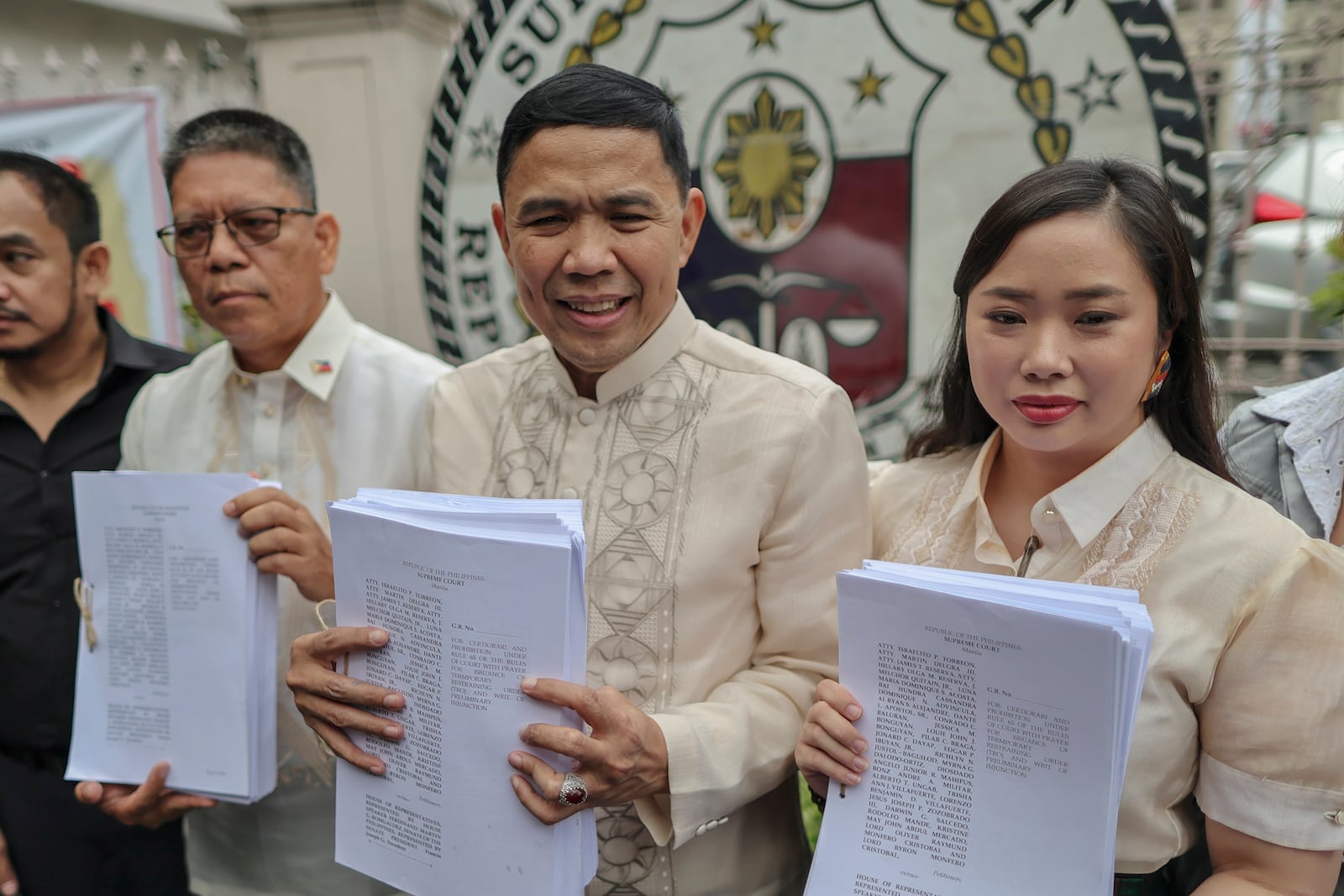 Philippine Vice President Sara Duterte's lawyers, from left, Atty. Martin Delgra, Atty. Israelito Torreon and Atty. Hillary Olga shows documents they filed asking the 15-member high court to annul her impeachment and block the trial at the Supreme Court in Manila, Philippines Tuesday, Feb. 18, 2025. (AP Photo/Gerard Carreon)