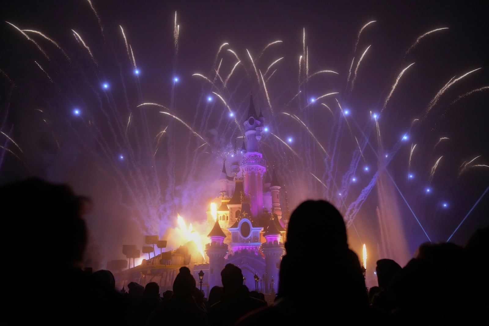 A light show is projected on the castle of Sleeping Beauty as fireworks explode in Disneyland, in Marne-la-Vallee, east of Paris, Friday Jan. 17, 2025. (AP Photo/Thibault Camus)