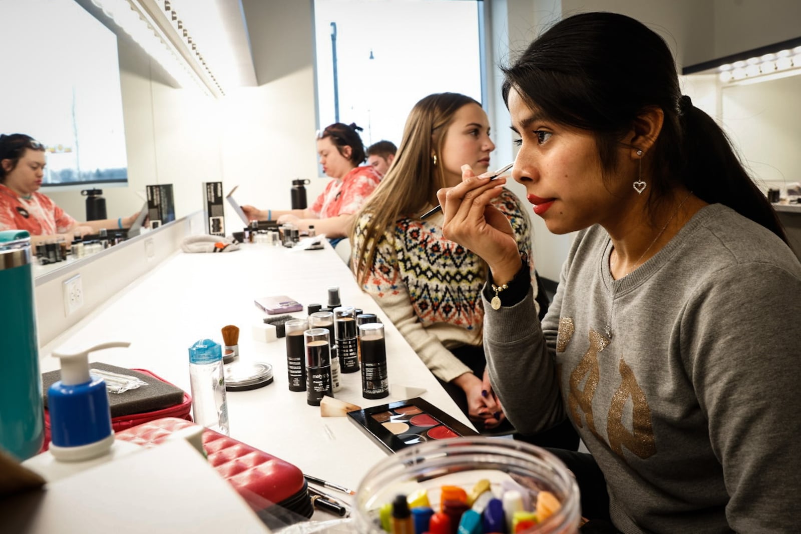 University of Dayton freshman Lizette Alavez applies theater makeup at the now open Roger Glass Center for the Arts. JIM NOELKER/STAFF