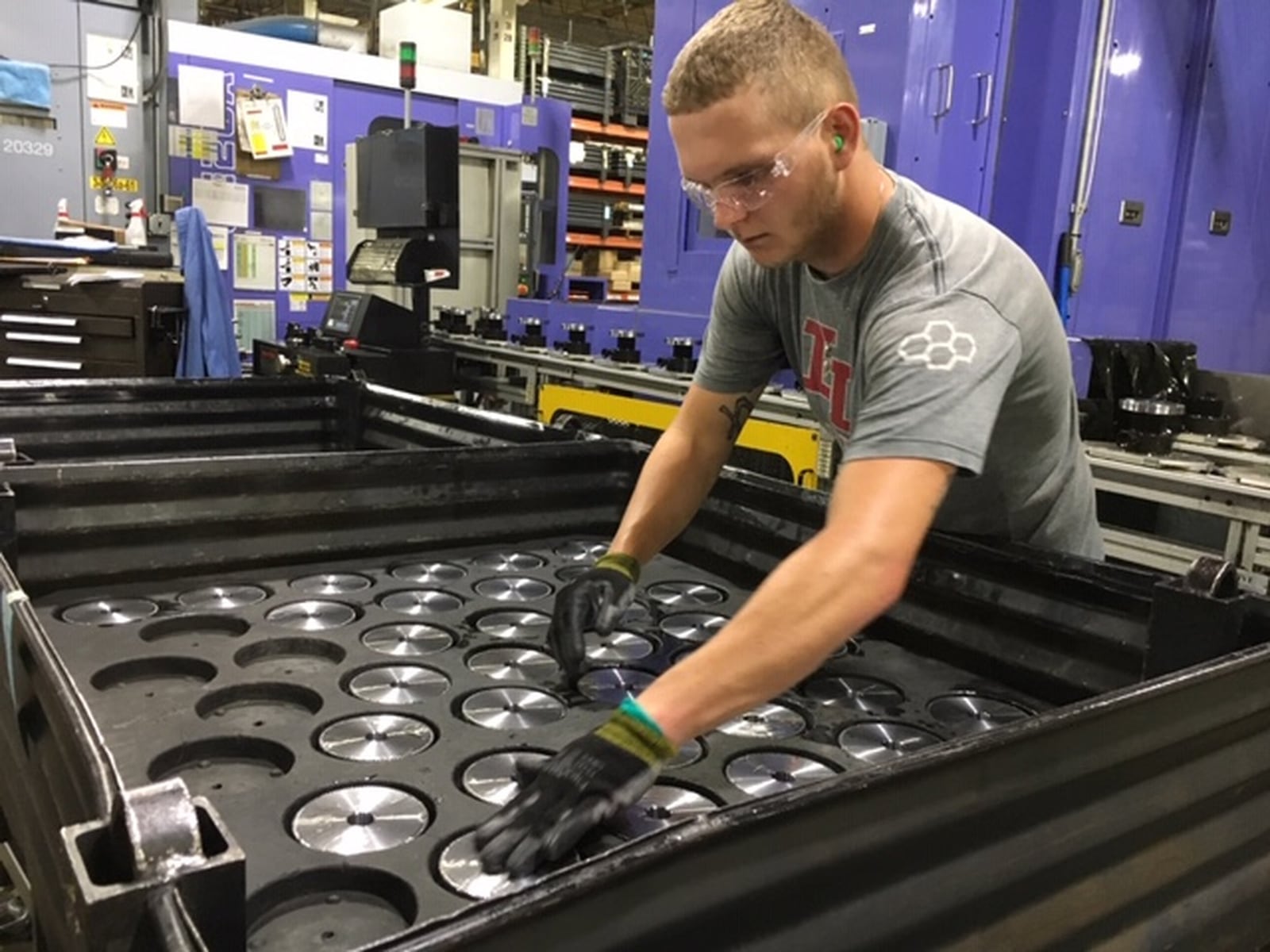 Michael Lensman arranges gears after cutting them on a Crown Equipment assembly line in New Bremen. THOMAS GNAU/STAFF