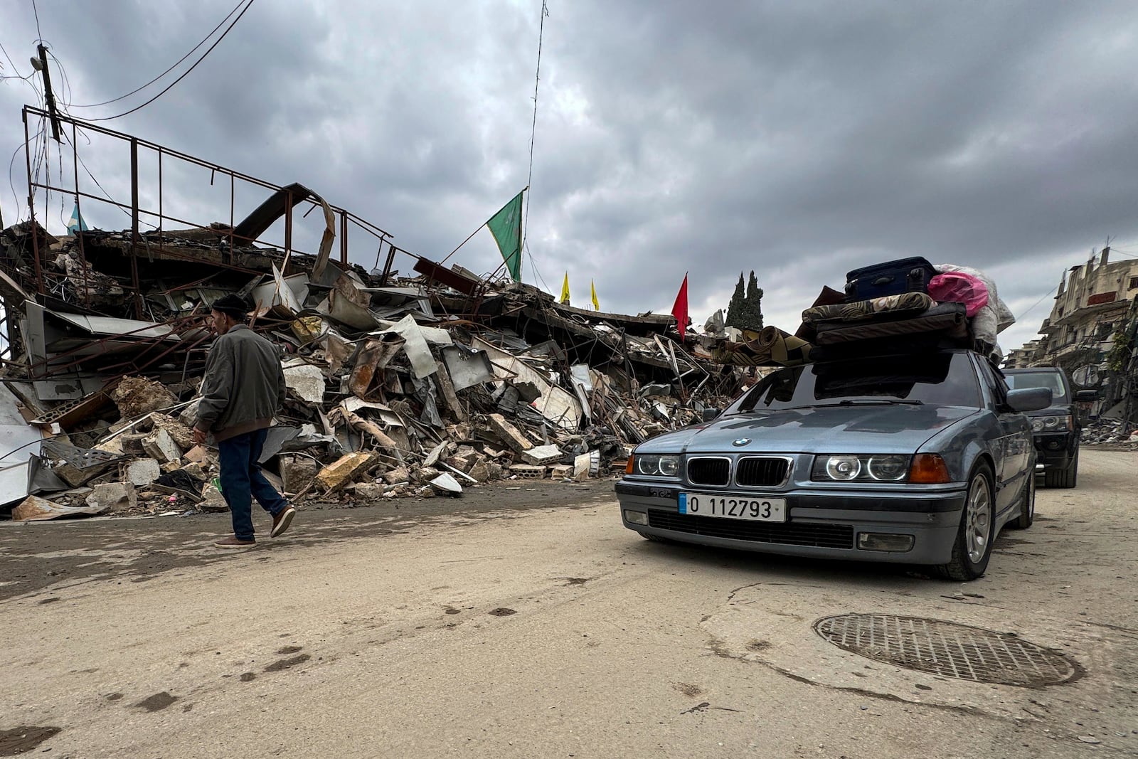 Displaced residents drive past destroyed buildings as they return to Nabatiyeh, southern Lebanon, Thursday, Nov. 28, 2024 following a ceasefire between Israel and Hezbollah that went into effect on Wednesday. (AP Photo/Bassam Hatoum)