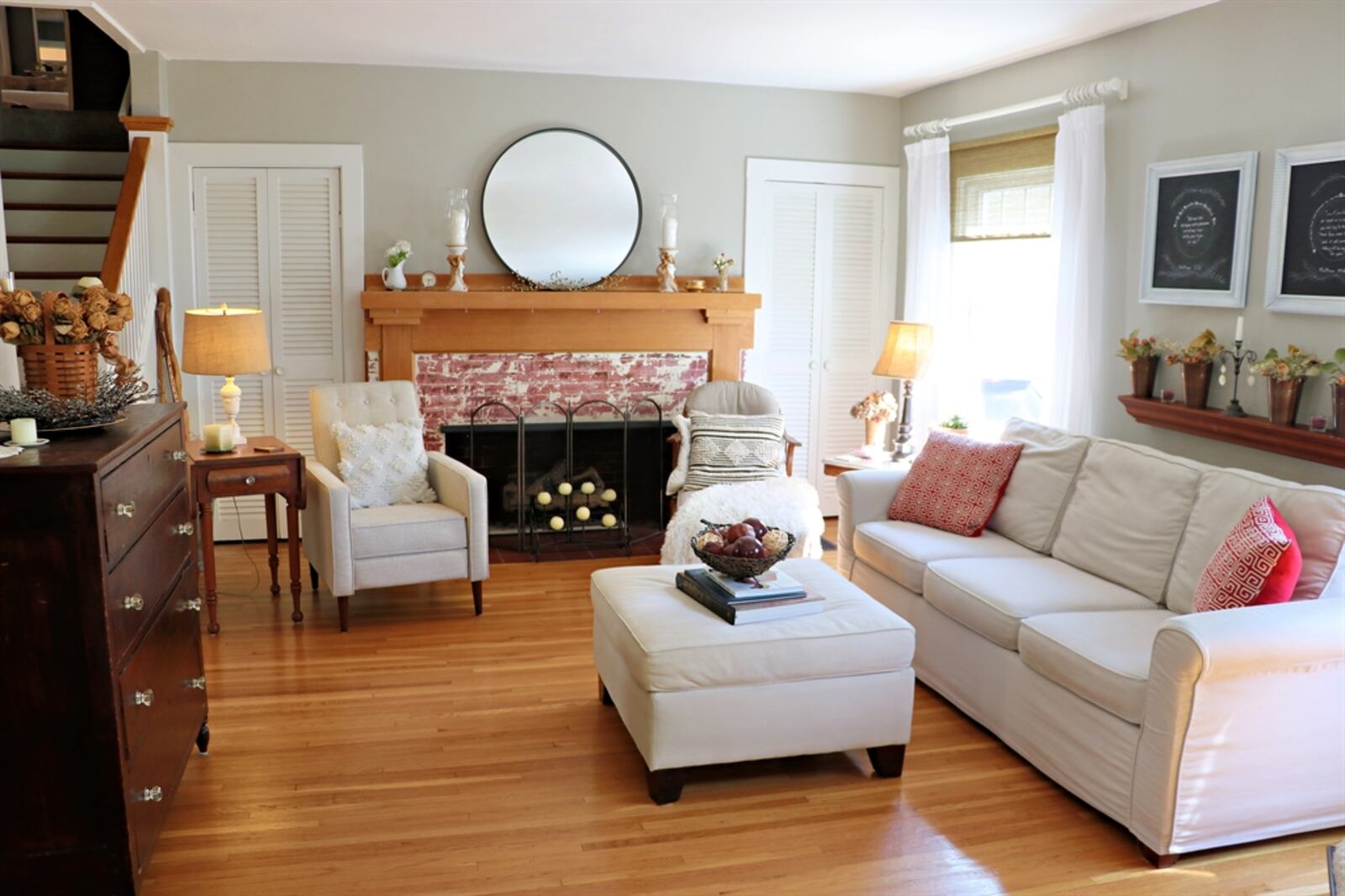 Oak hardwood flooring fills the living room and continues into the adjoining dining room. A decorative fireplace has distressed, painted brick surround and a wood mantel. 