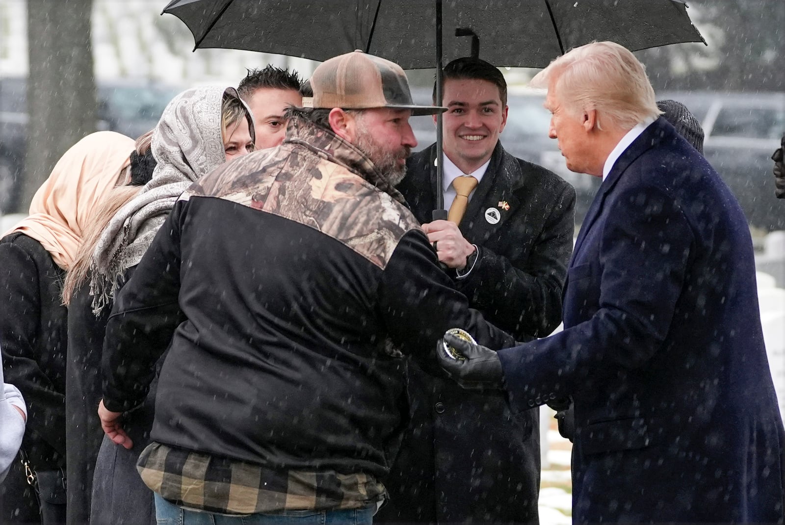 President-elect Donald Trump greets family members at the grave of Marine Corps Sgt. Nicole Gee in Section 60 at Arlington National Cemetery, Sunday, Jan. 19, 2025, in Arlington, Va. (AP Photo/Evan Vucci)